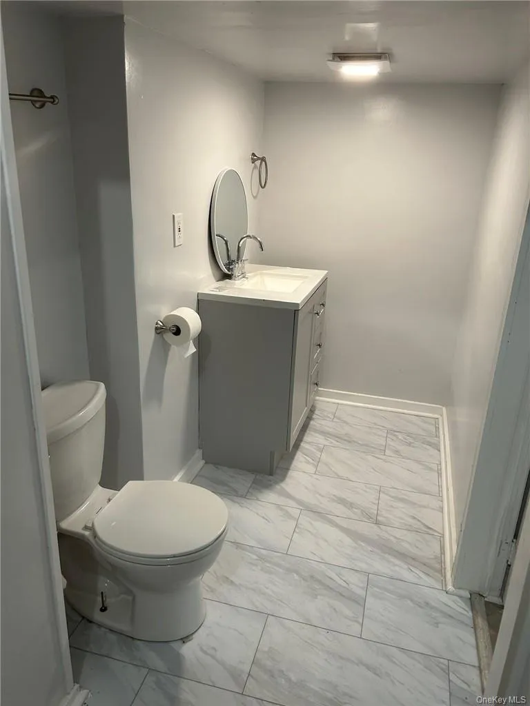 Bathroom featuring tile flooring, vanity, and toilet Bathroom featuring tile flooring, vanity, and toilet
