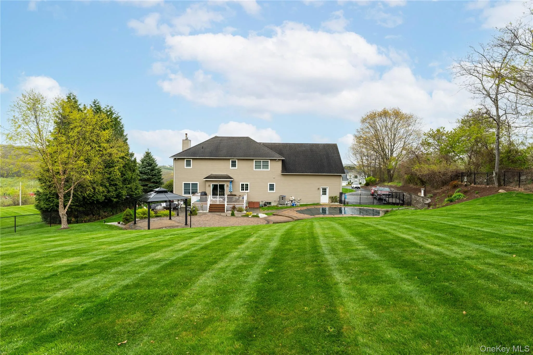 Rear facade featuring a patio with a gazebo, an inground pool, and an expansive lawn Rear facade featuring a patio with a gazebo, an inground pool, and an expansive lawn