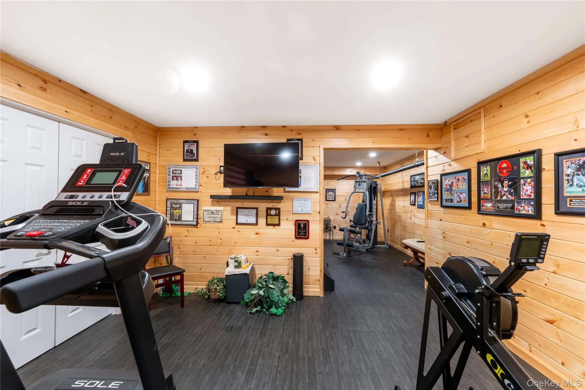 Basement Recreational room featuring Pine wood-panel walls, rubber flooring, and recessed lighting Basement Recreational room featuring Pine wood-panel walls, rubber flooring, and recessed lighting