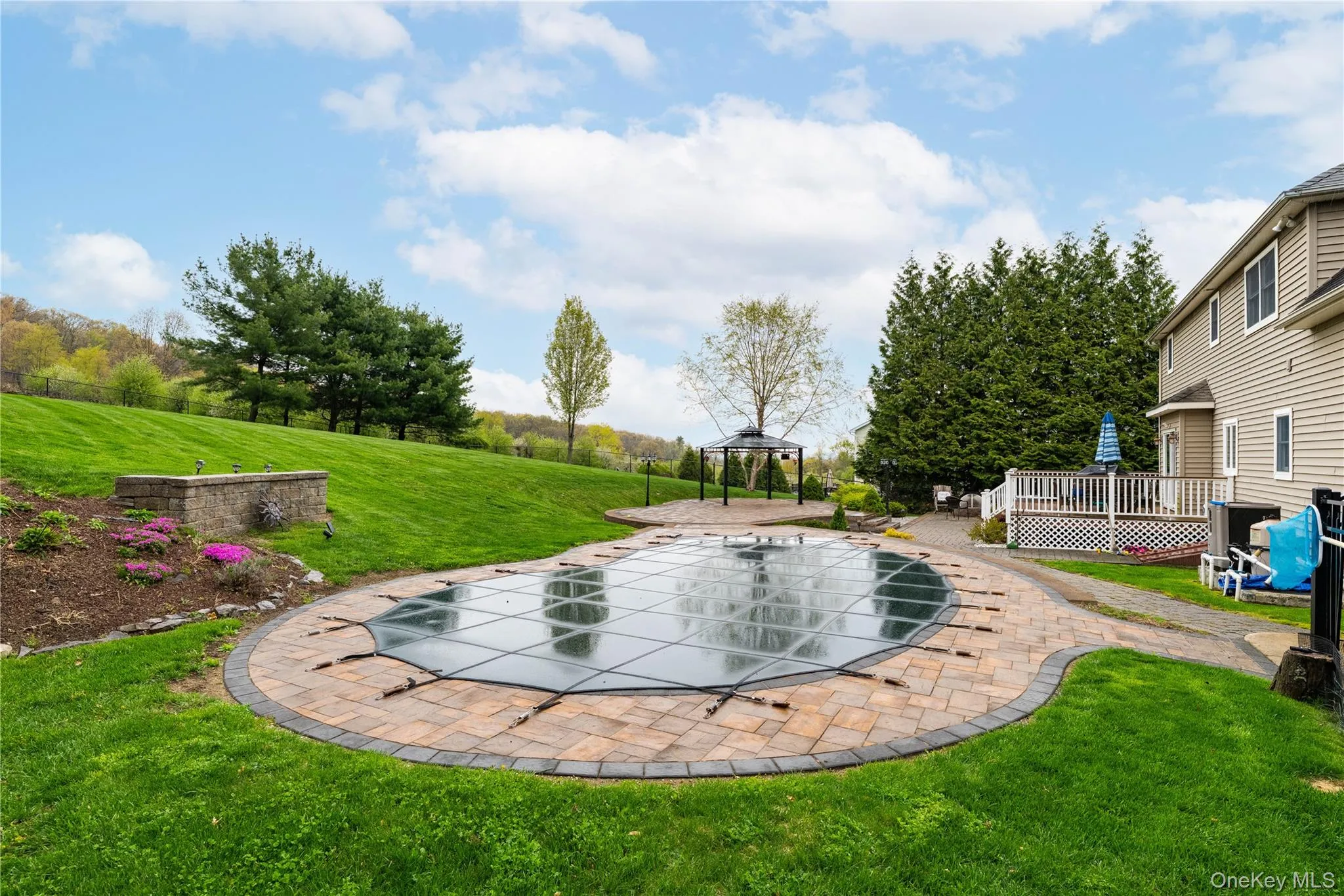 Expansive backyard featuring a covered heated-salt water pool with paver surround Expansive backyard featuring a covered heated-salt water pool with paver surround