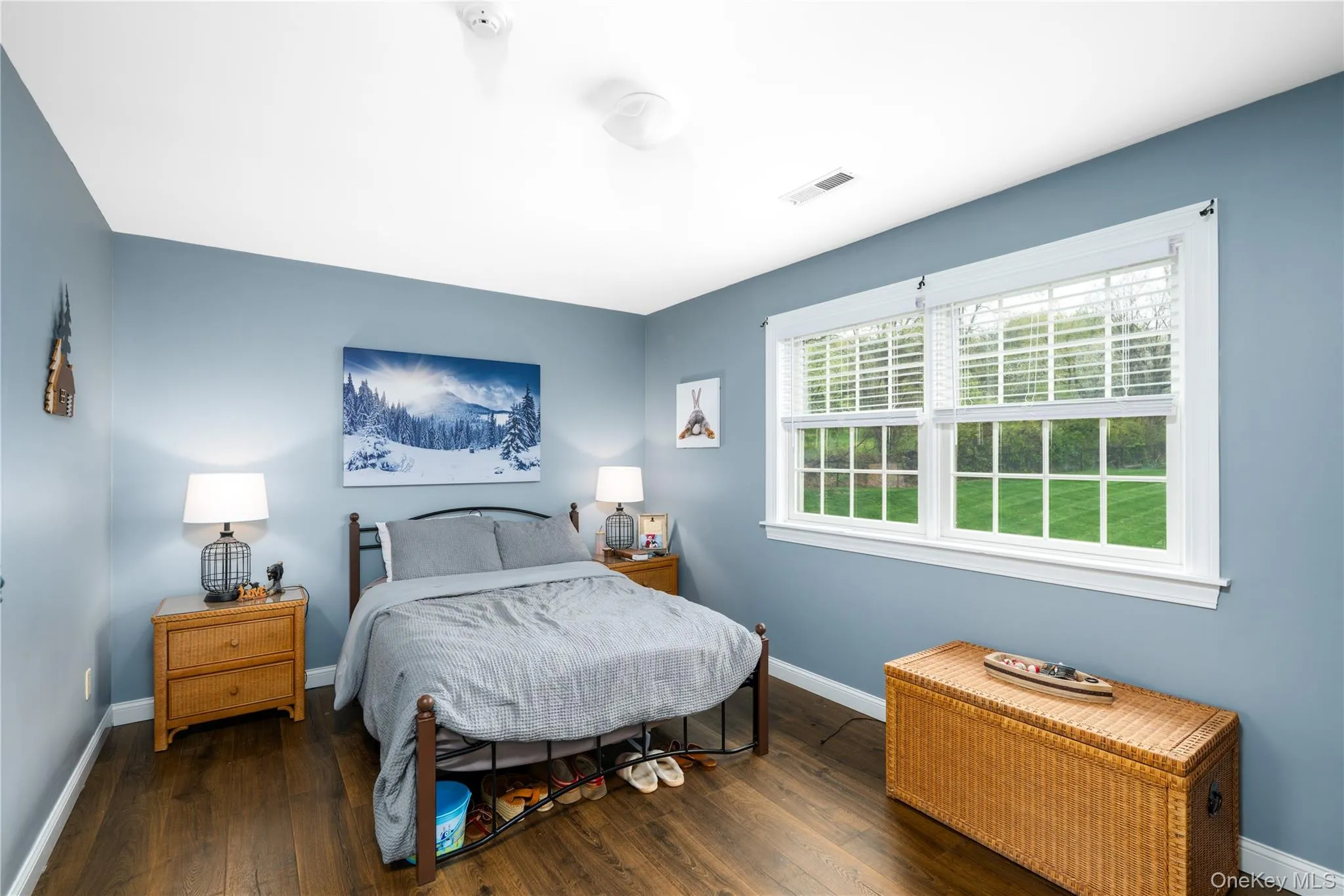 Bedroom room featuring wood-finish flooring and a light blue wall color Bedroom room featuring wood-finish flooring and a light blue wall color
