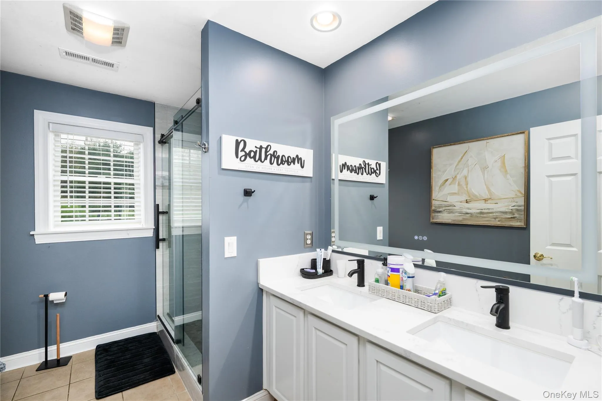 Dual vanity with white cabinetry, integrated granite counter sinks, and matte black fixtures Dual vanity with white cabinetry, integrated granite counter sinks, and matte black fixtures