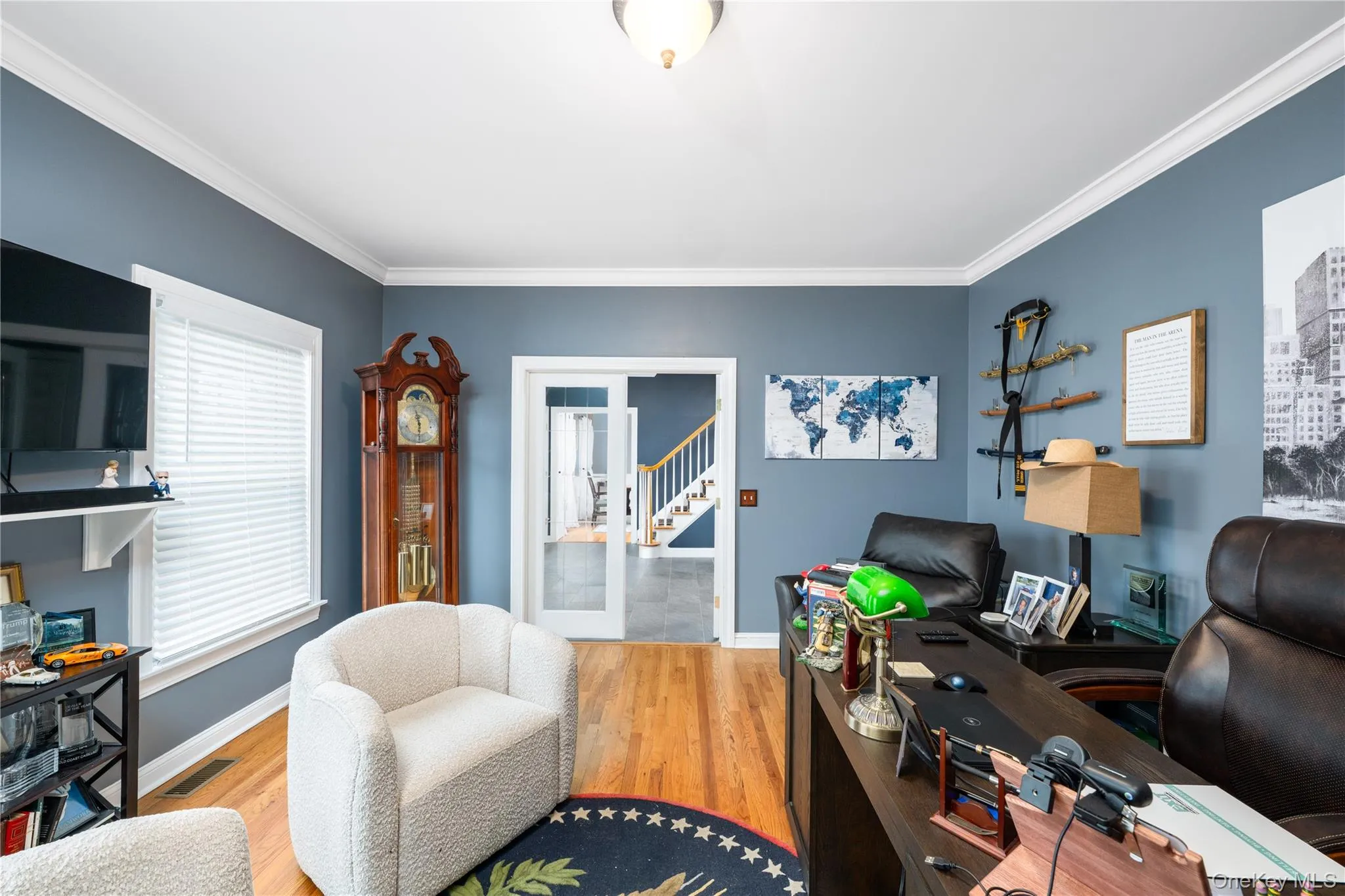 Hardwood flooring, crown molding, and neutral wall paint define this interior space Hardwood flooring, crown molding, and neutral wall paint define this interior space