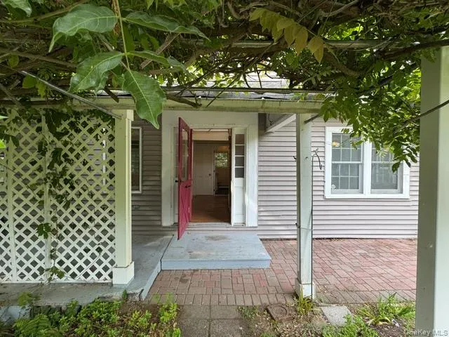 Covered entryway with robust columns and an overhead trellis Covered entryway with robust columns and an overhead trellis
