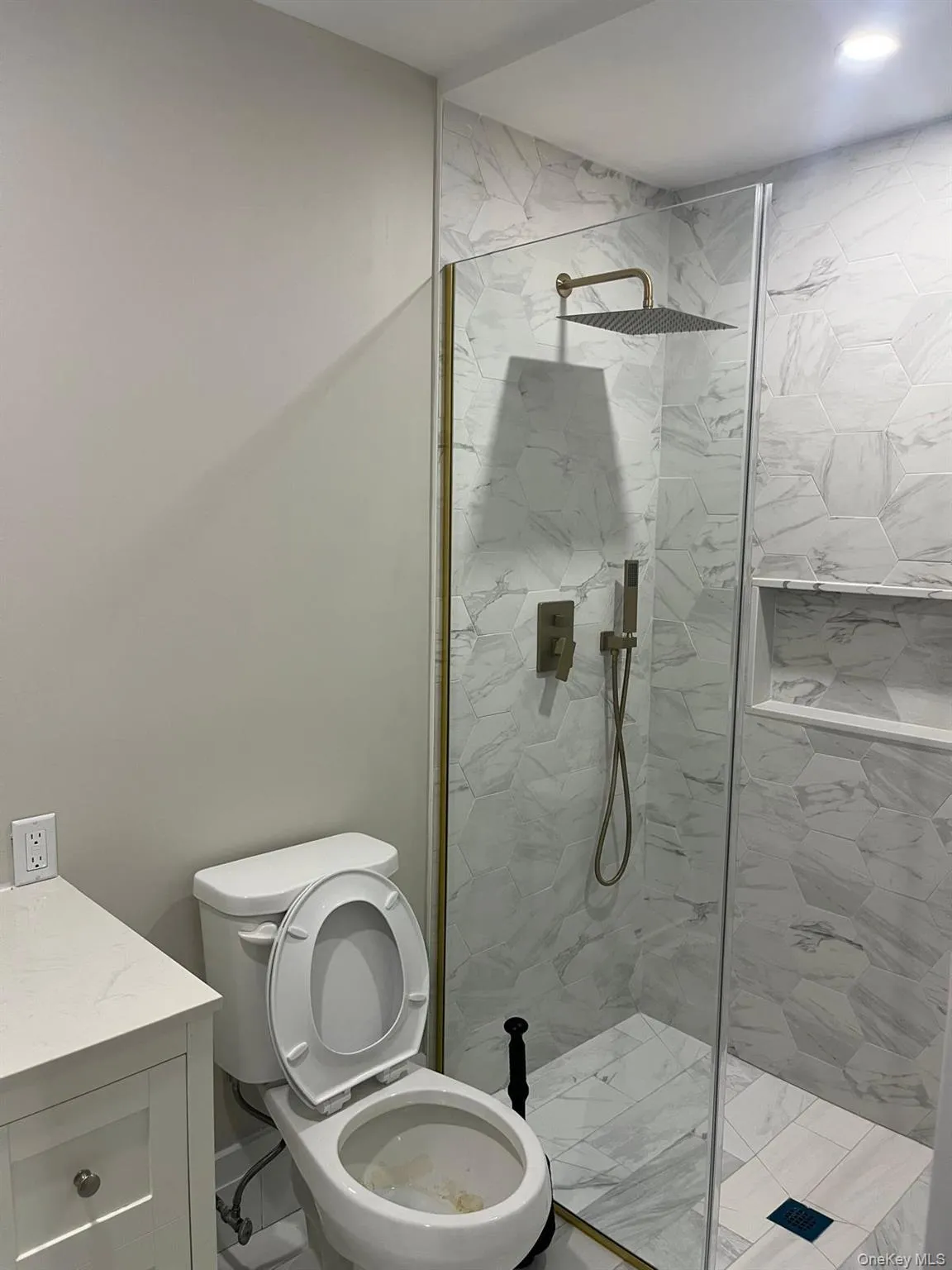 Bathroom with tiled shower, vanity, and toilet Bathroom with tiled shower, vanity, and toilet