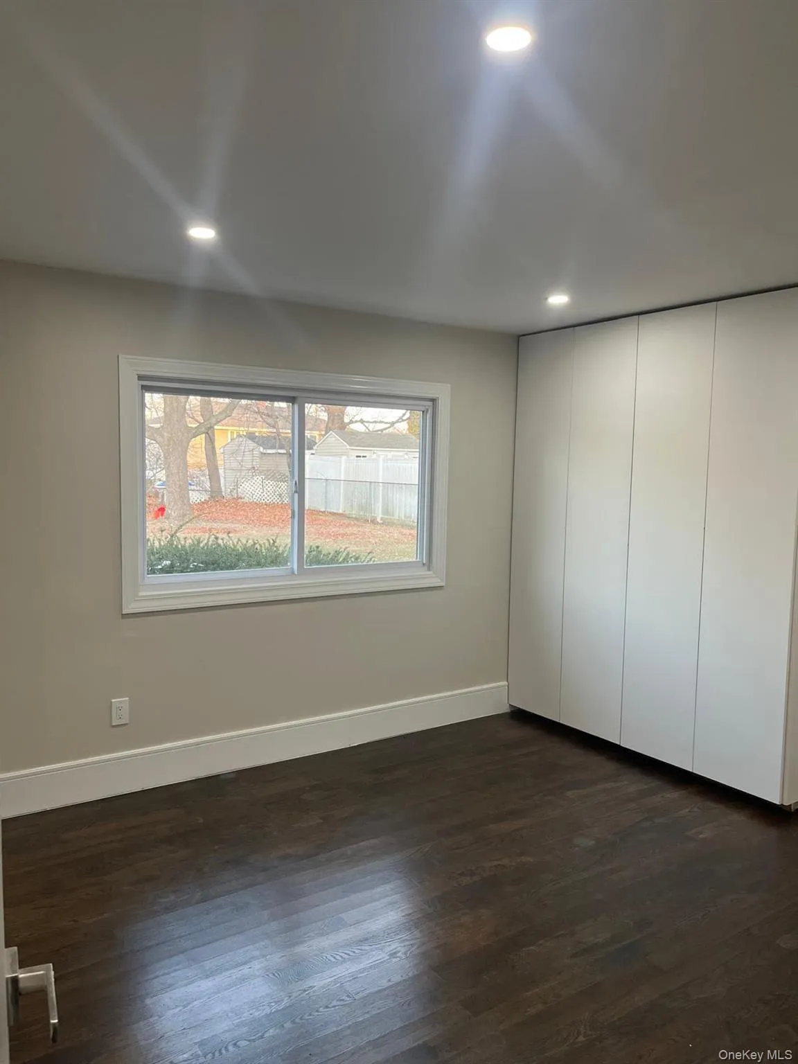Unfurnished bedroom with a closet and dark wood-type flooring Unfurnished bedroom with a closet and dark wood-type flooring
