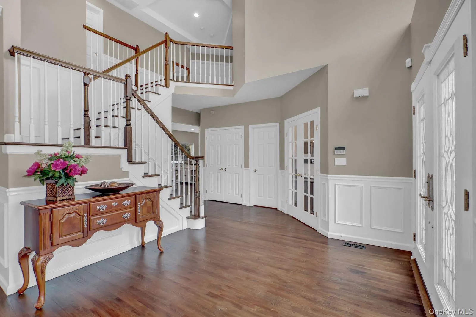 Grand Foyer Featuring a Two-Story Ceiling, Hardwood Floors and Custom Trim and Finishes Grand Foyer Featuring a Two-Story Ceiling, Hardwood Floors and Custom Trim and Finishes