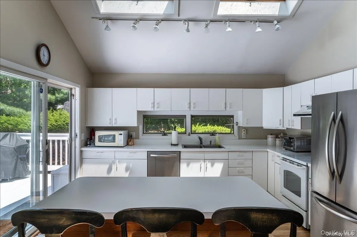 Kitchen featuring white cabinetry, stainless steel appliances, and a central island Kitchen featuring white cabinetry, stainless steel appliances, and a central island