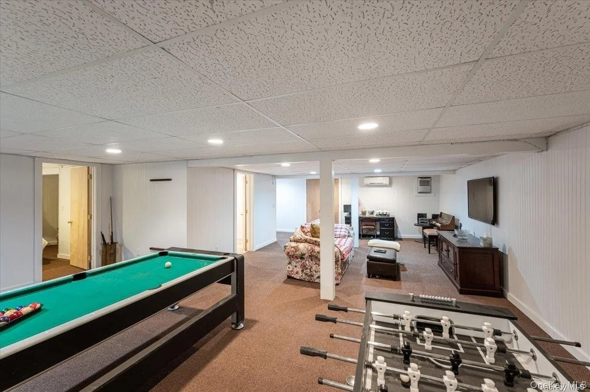 Spacious finished lower level featuring recessed lighting, paneled walls, and carpeted flooring Spacious finished lower level featuring recessed lighting, paneled walls, and carpeted flooring