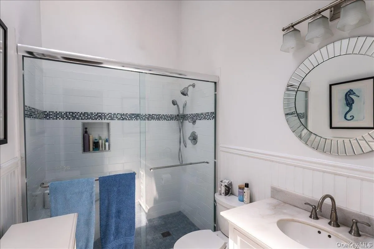 Shower with glass enclosure, white subway tile surround with mosaic accent, and recessed niche Shower with glass enclosure, white subway tile surround with mosaic accent, and recessed niche