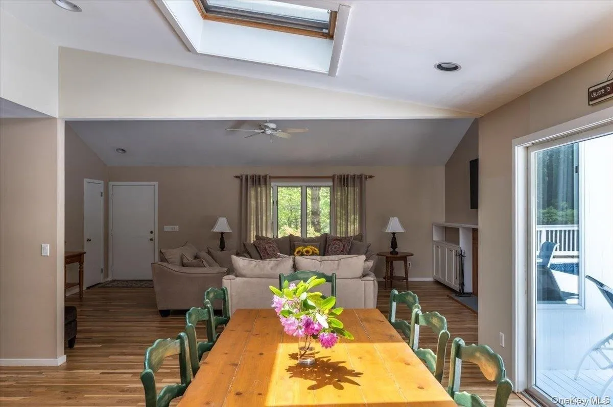 Open-concept interior featuring wood-finish flooring, a skylight, and recessed lighting Open-concept interior featuring wood-finish flooring, a skylight, and recessed lighting