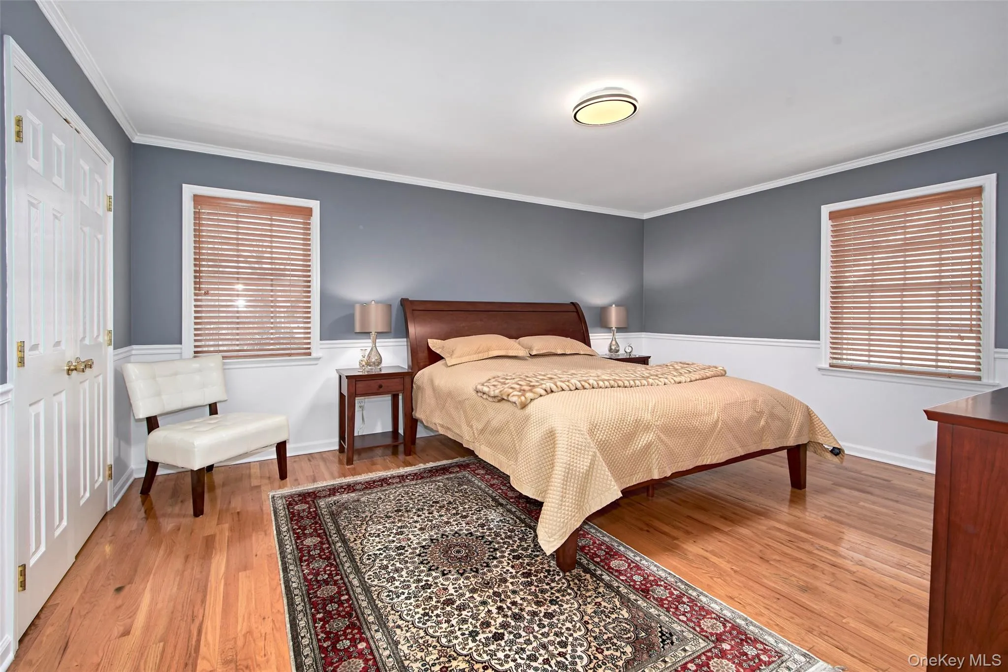 Bedroom featuring ornamental molding and light wood-type flooring Bedroom featuring ornamental molding and light wood-type flooring