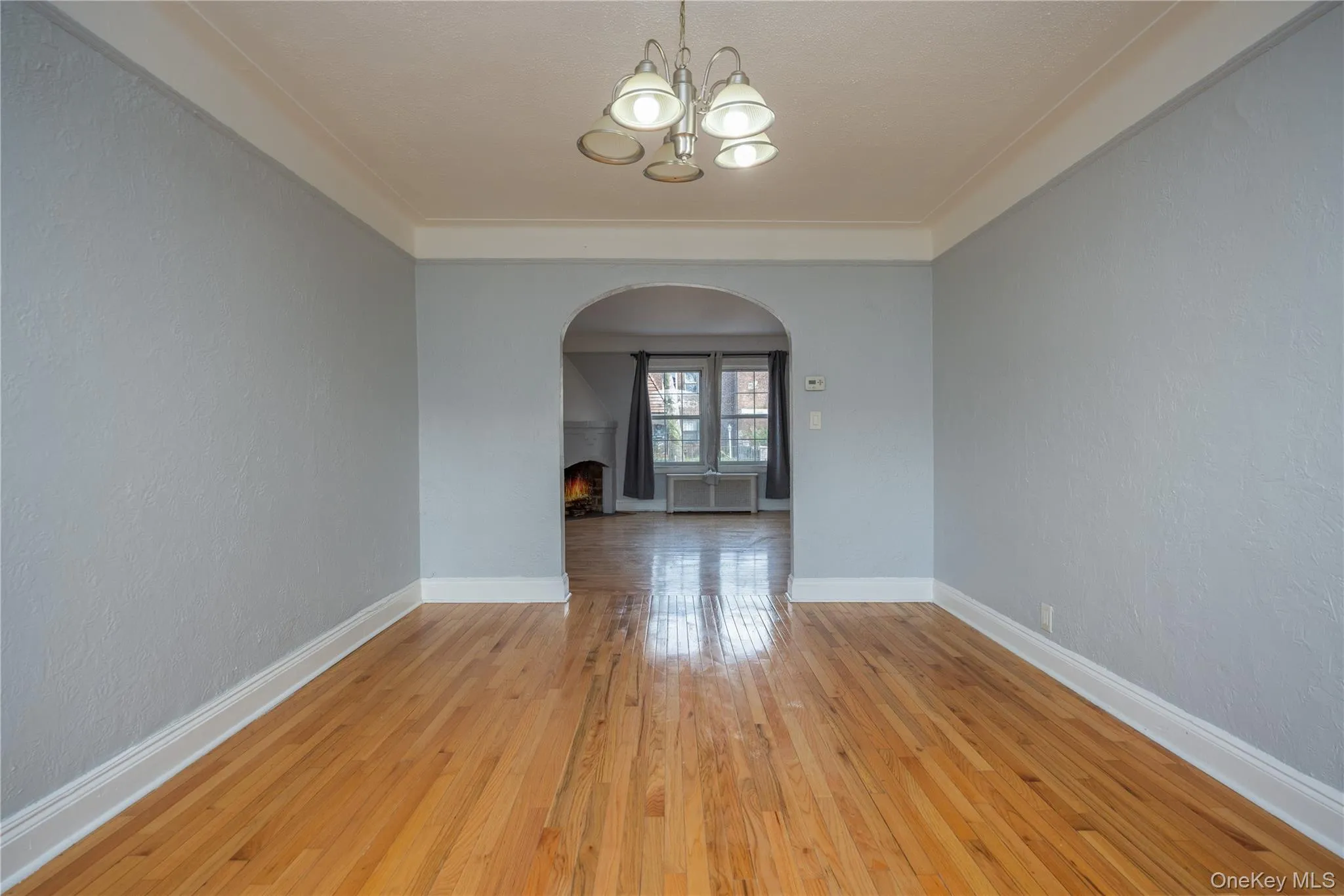 Dining Room10'6" x 14'9"Hardwood flooring extends throughout, complemented by a decorative arched doorway, light gray walls and white trim Dining Room10'6" x 14'9"Hardwood flooring extends throughout, complemented by a decorative arched doorway, light gray walls and white trim