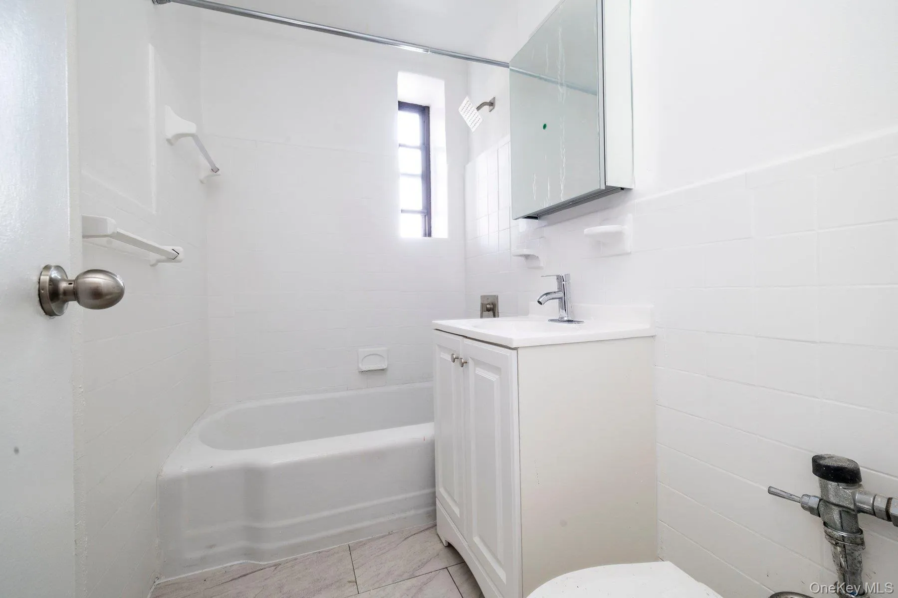 Bathroom featuring a white vanity with a single basin sink, chrome faucet, and mirrored medicine cabinet Bathroom featuring a white vanity with a single basin sink, chrome faucet, and mirrored medicine cabinet