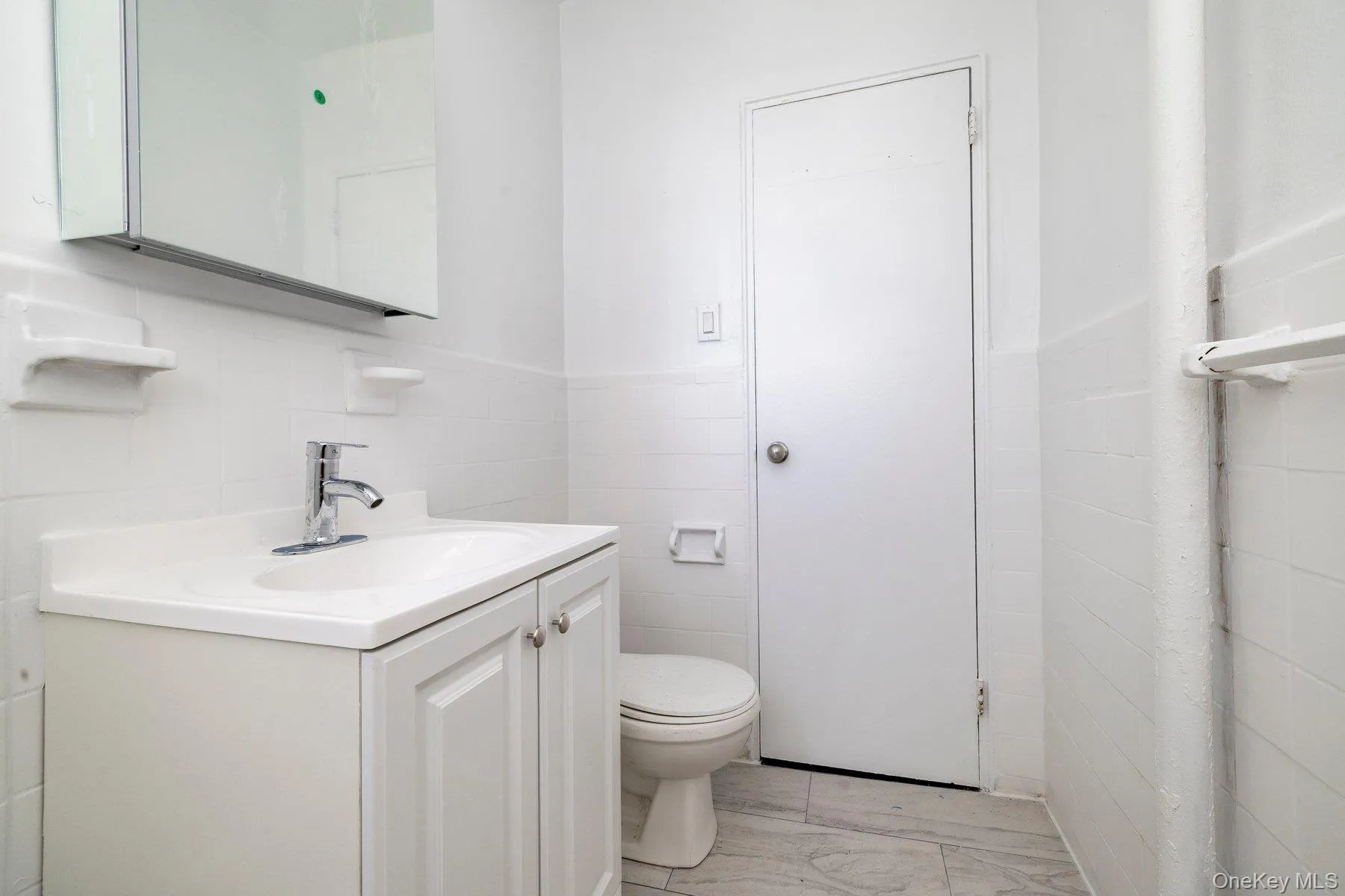 White vanity with an integrated sink and chrome faucet White vanity with an integrated sink and chrome faucet