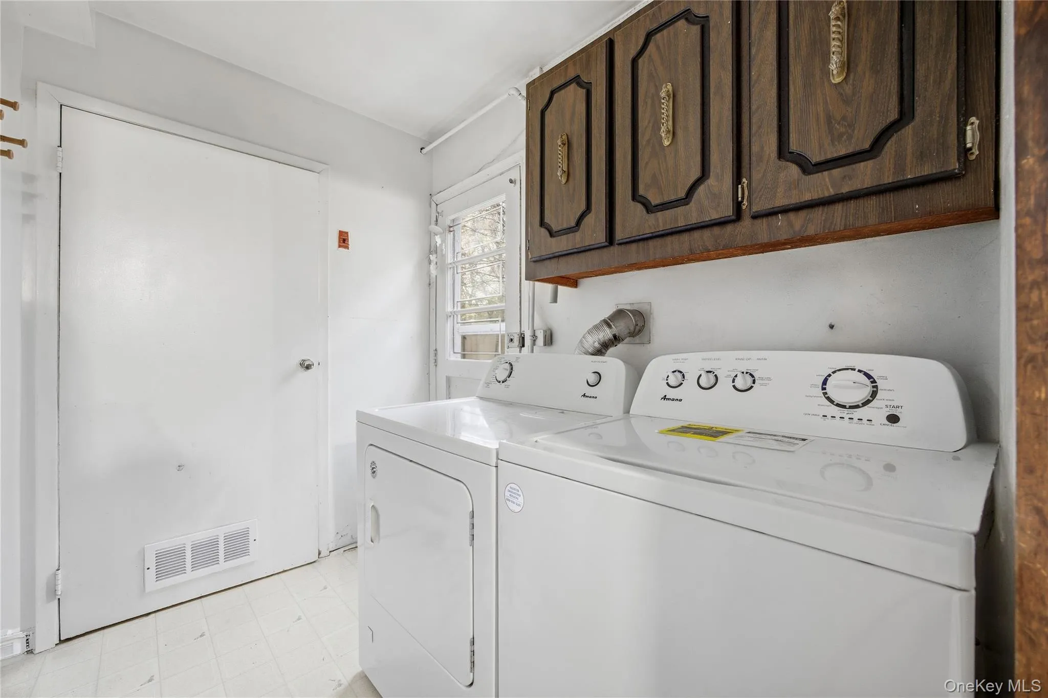 Dedicated laundry area featuring a white top-load washing machine and front-load dryer Dedicated laundry area featuring a white top-load washing machine and front-load dryer