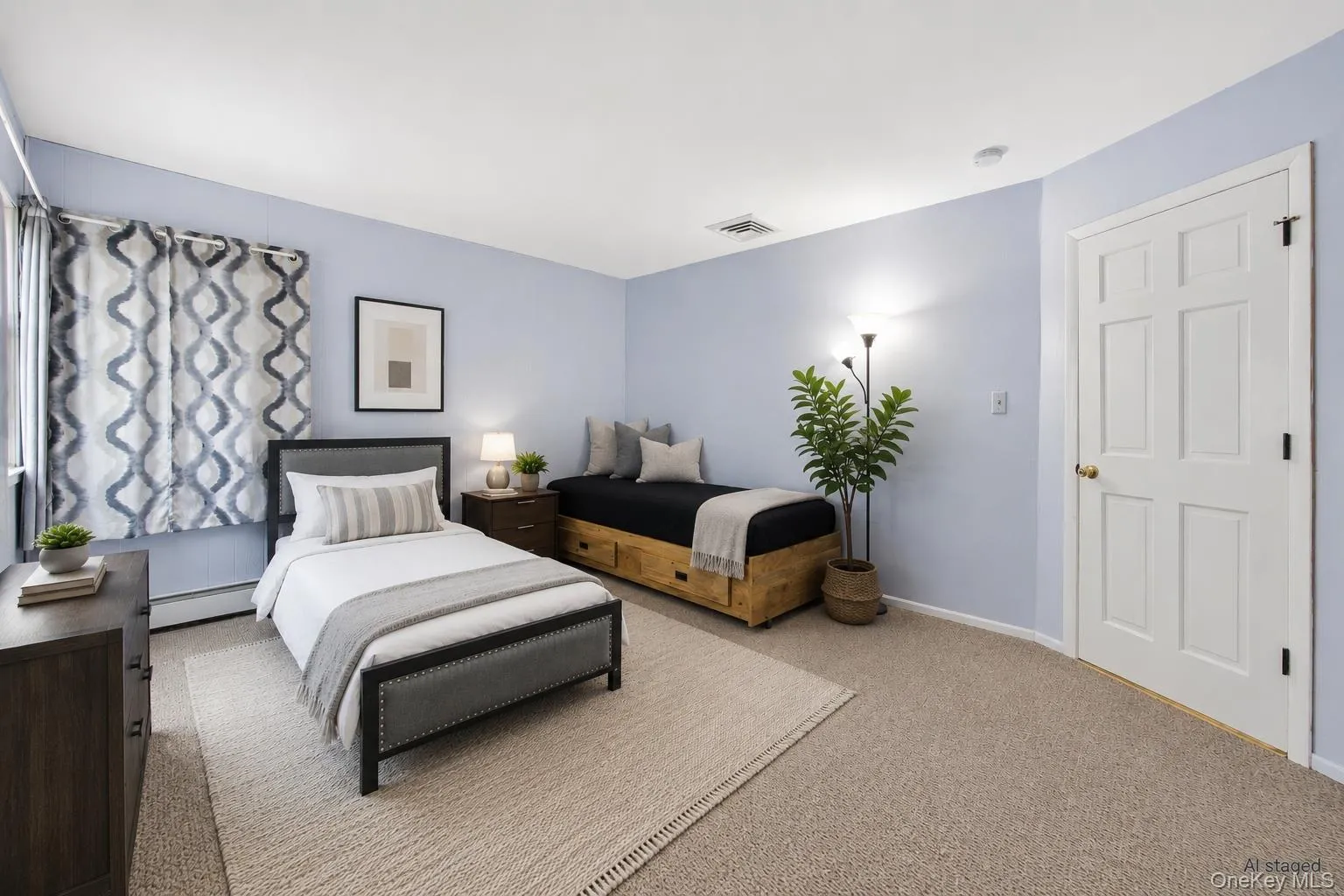 Bedroom featuring light blue walls, tan carpeting, a white six-panel door, and a window with patterned drapes Bedroom featuring light blue walls, tan carpeting, a white six-panel door, and a window with patterned drapes