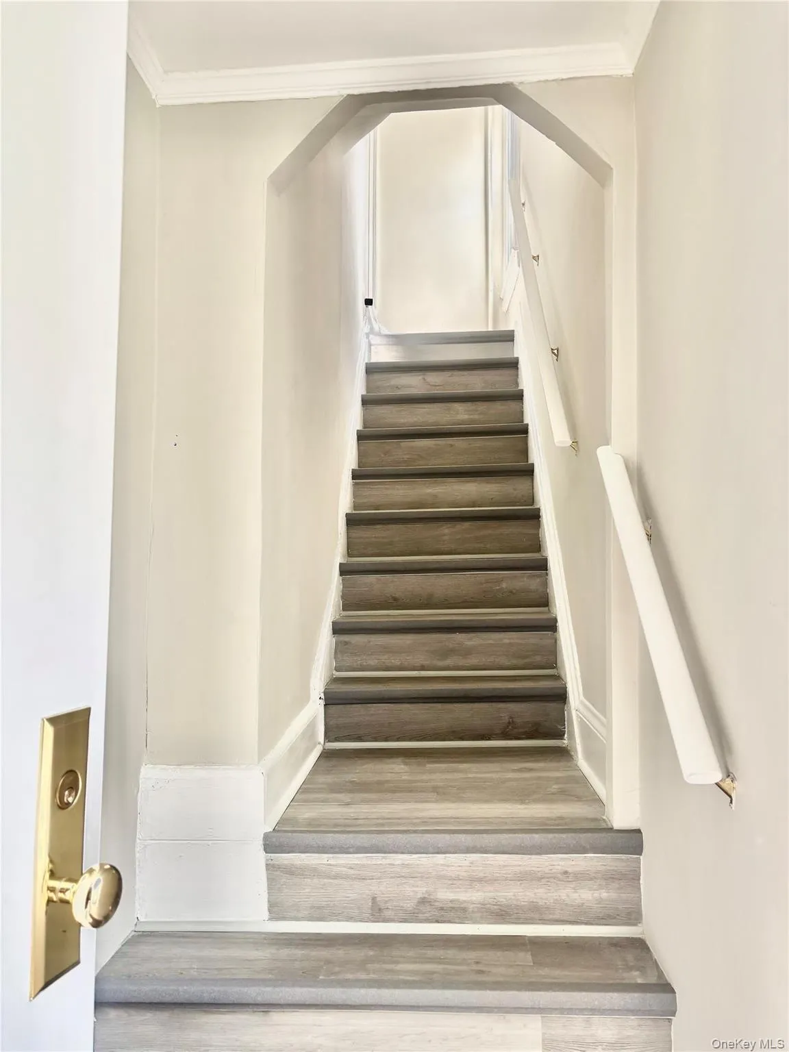 Staircase featuring wood-finish treads, white risers, and a white handrail3 Staircase featuring wood-finish treads, white risers, and a white handrail3