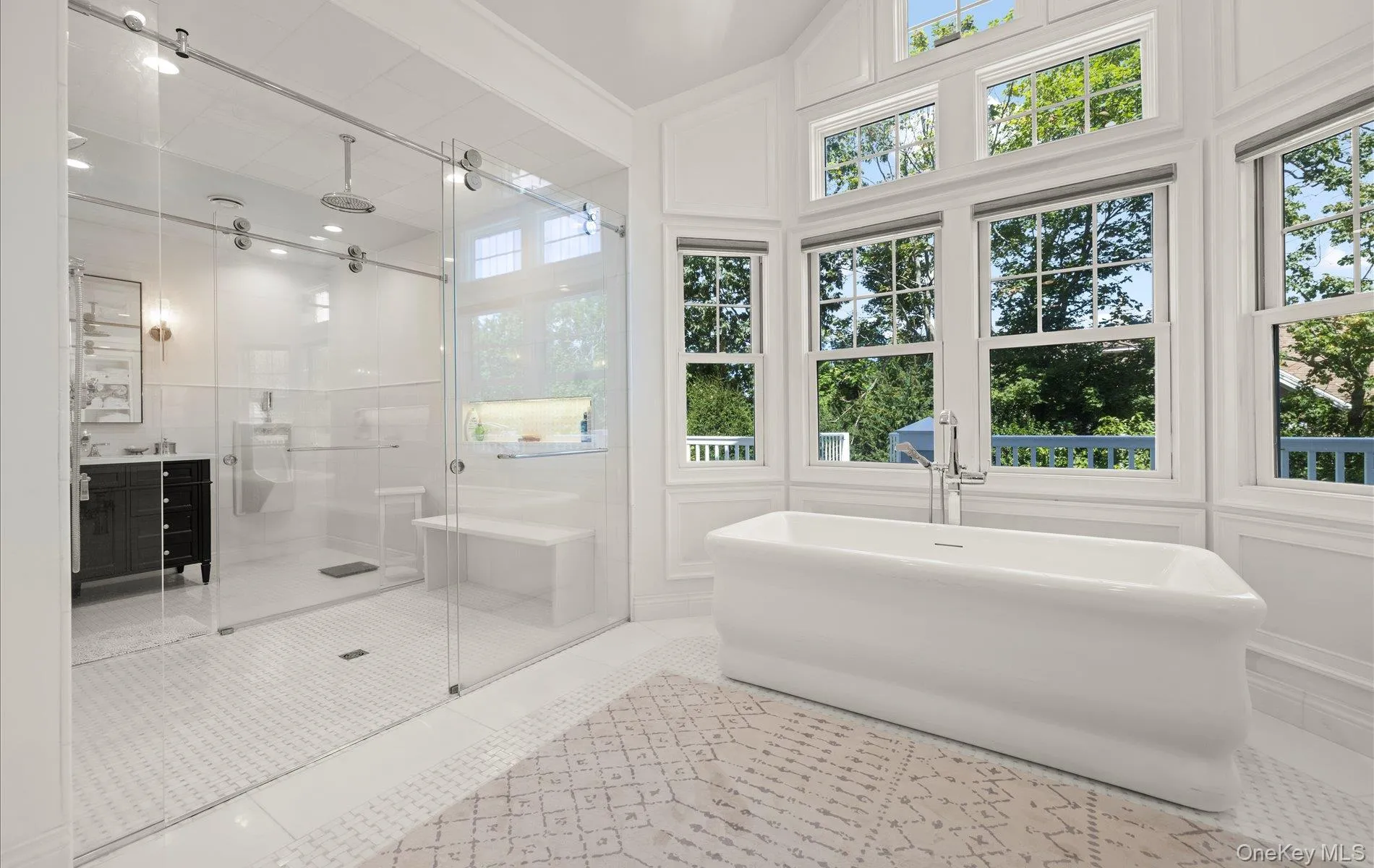 Soaking tub with a floor-mounted faucet, surrounded by multiple large windows and transom windows Soaking tub with a floor-mounted faucet, surrounded by multiple large windows and transom windows
