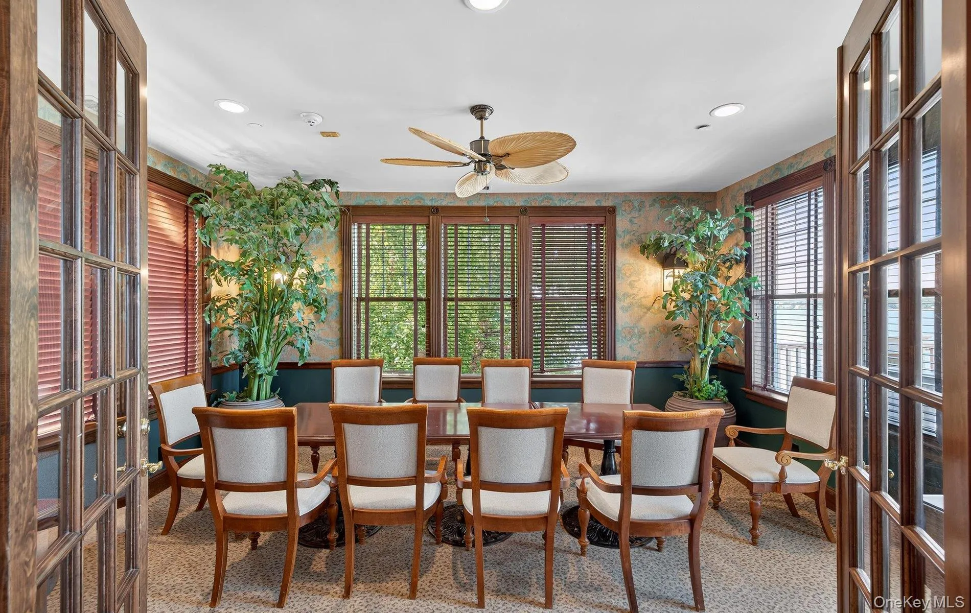 Spacious room featuring multiple large windows with horizontal blinds, decorative wall coverings, a ceiling fan, and recessed lighting Spacious room featuring multiple large windows with horizontal blinds, decorative wall coverings, a ceiling fan, and recessed lighting