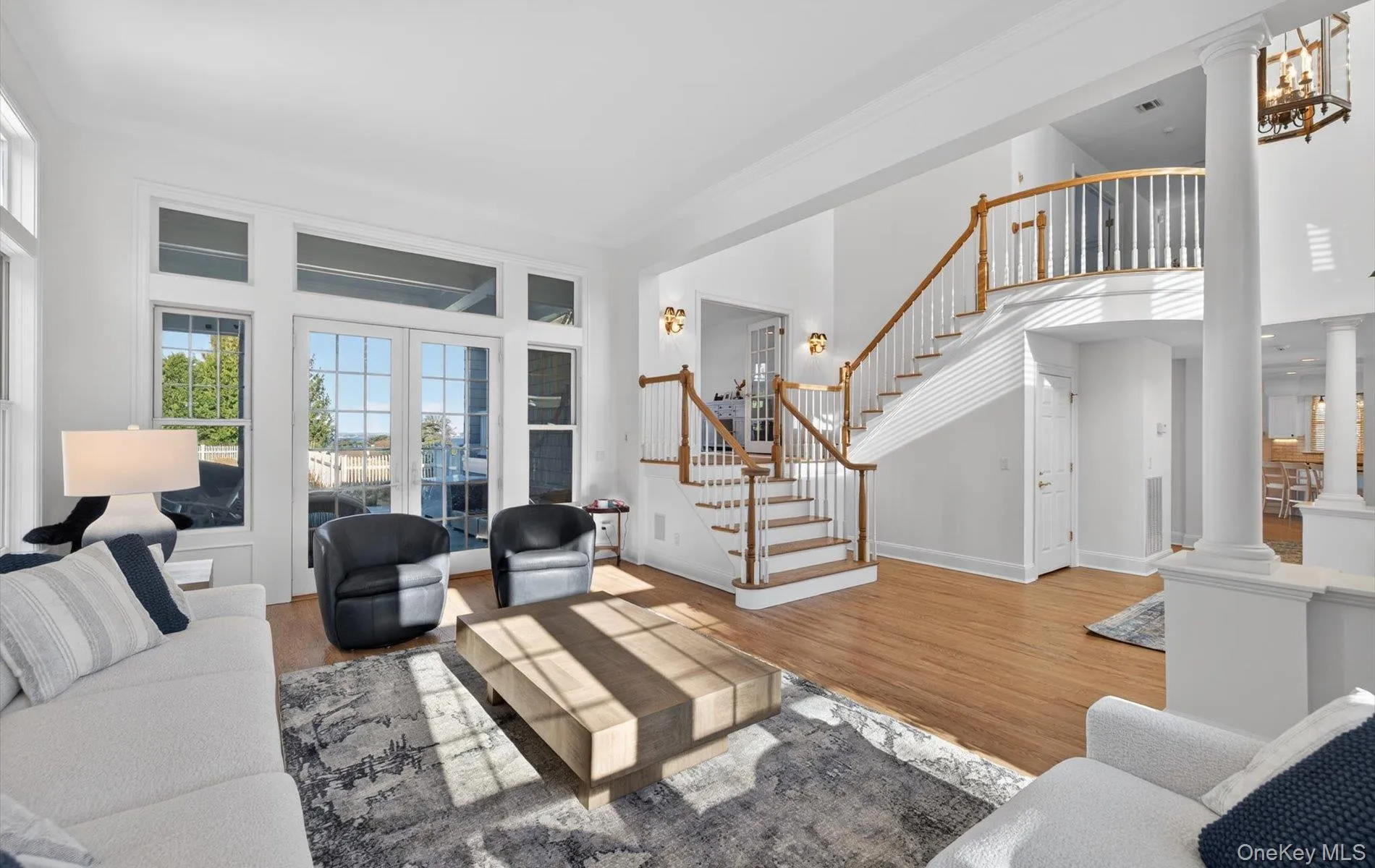 Two-story foyer with a grand staircase featuring white spindles and a wood handrail Two-story foyer with a grand staircase featuring white spindles and a wood handrail