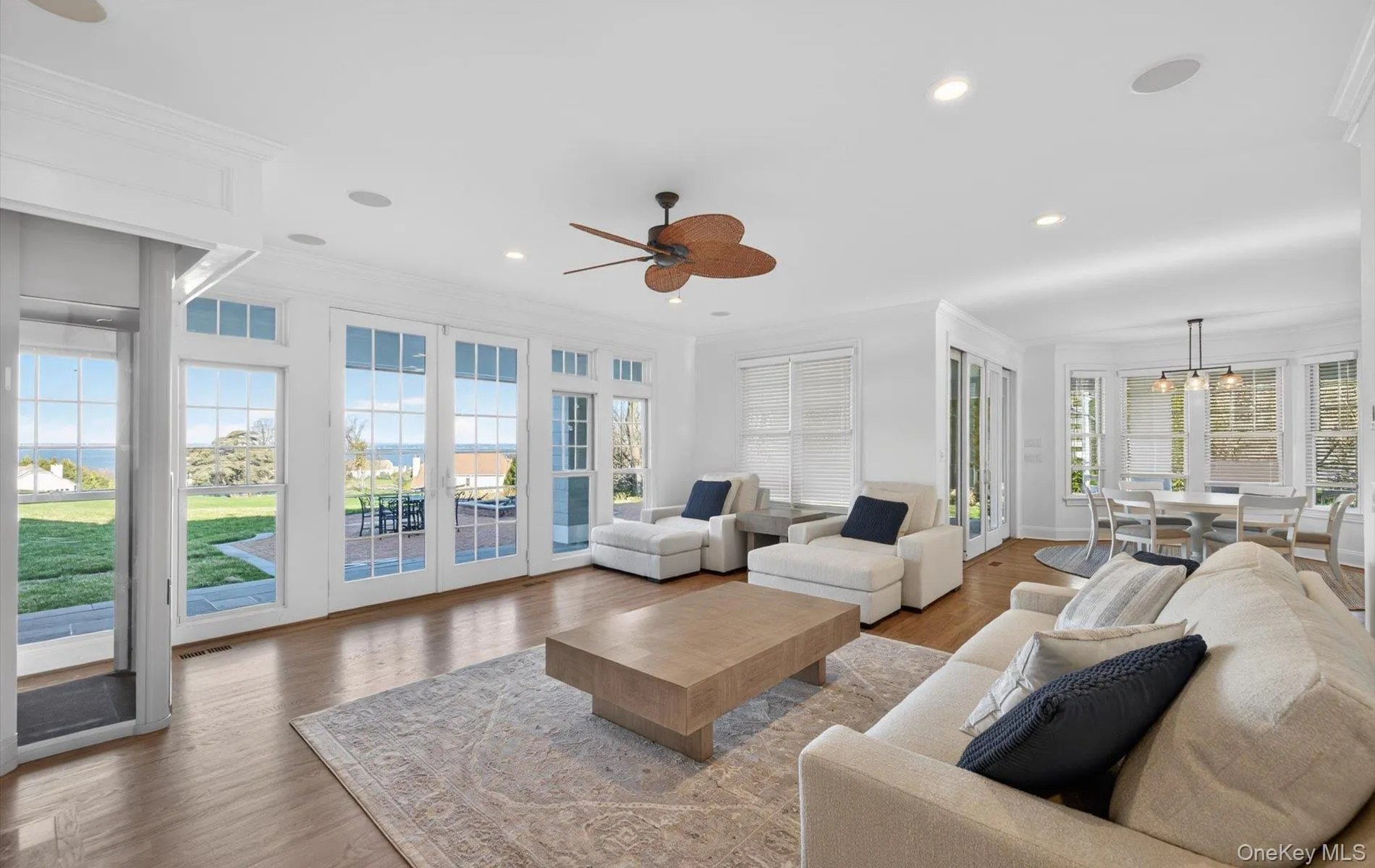 Bright living space with wood-finish flooring and extensive white French doors Bright living space with wood-finish flooring and extensive white French doors