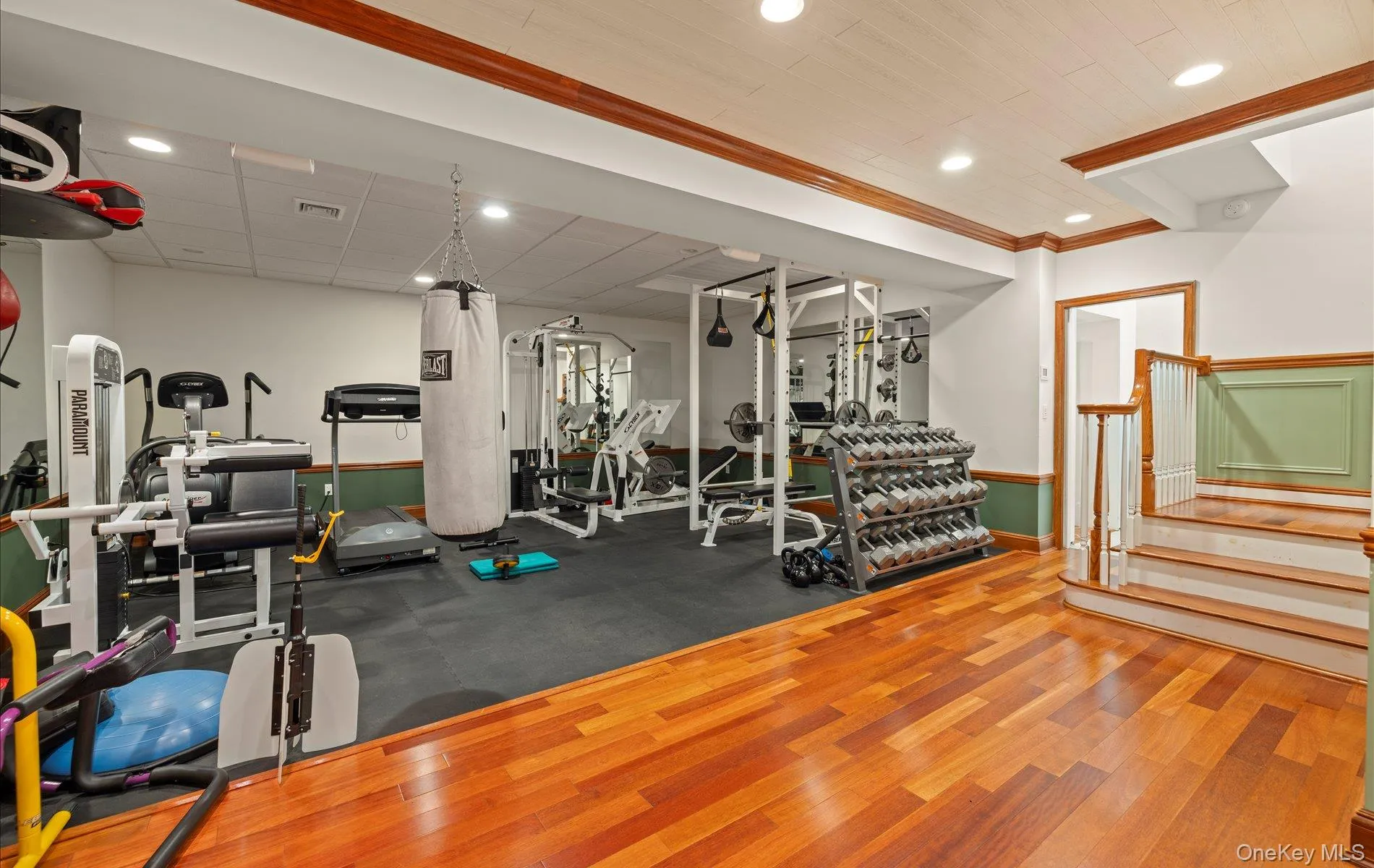 Dedicated fitness area featuring rubber flooring, recessed lighting, and a wood-finish flooring portion Dedicated fitness area featuring rubber flooring, recessed lighting, and a wood-finish flooring portion