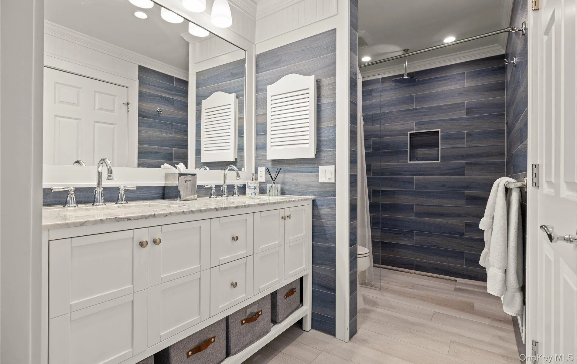 Dual vanity with white cabinetry, polished chrome fixtures, and a light-toned countertop Dual vanity with white cabinetry, polished chrome fixtures, and a light-toned countertop