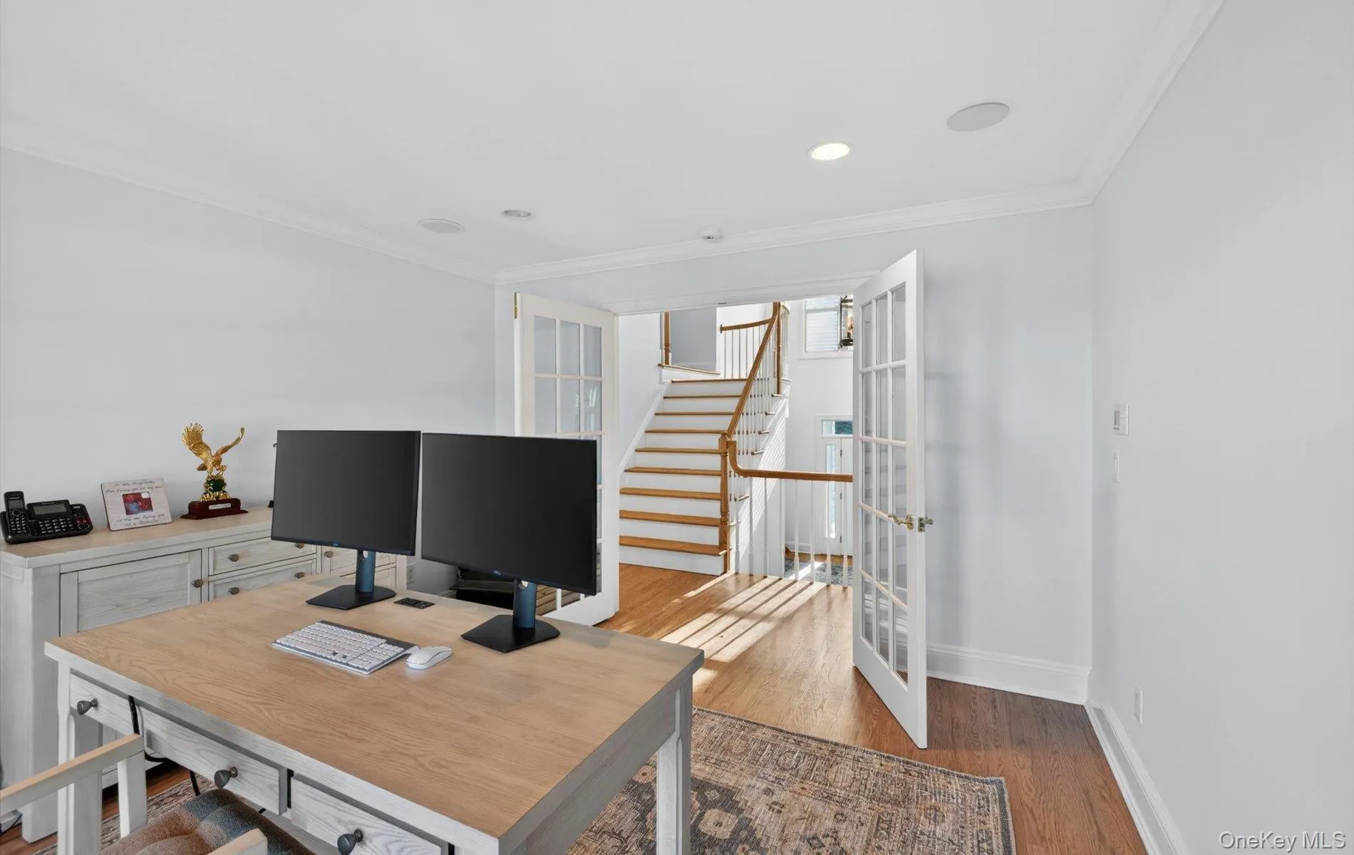 Home office featuring French doors, recessed lighting, crown molding, and wood-finish flooring Home office featuring French doors, recessed lighting, crown molding, and wood-finish flooring