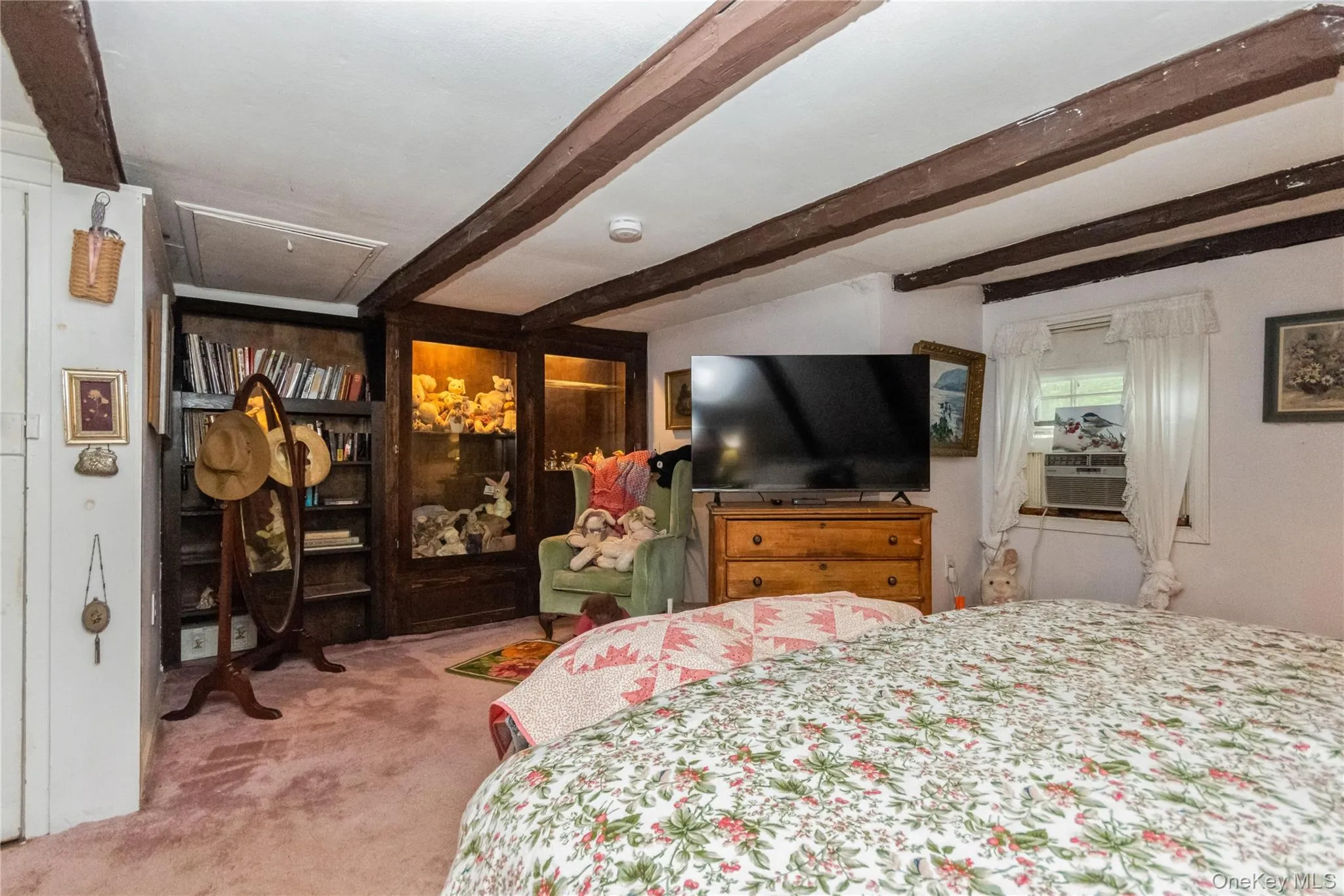 Bedroom featuring beam ceiling, carpet over Wide Board floors, and attic access Bedroom featuring beam ceiling, carpet over Wide Board floors, and attic access
