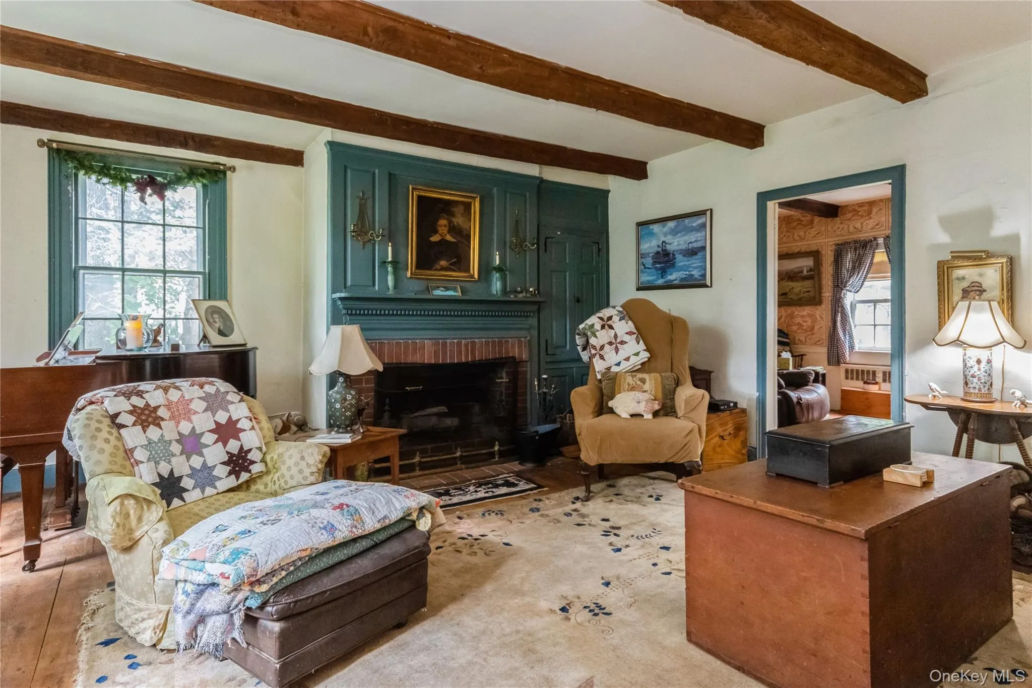 Living room featuring beamed ceiling and a brick fireplace Living room featuring beamed ceiling and a brick fireplace