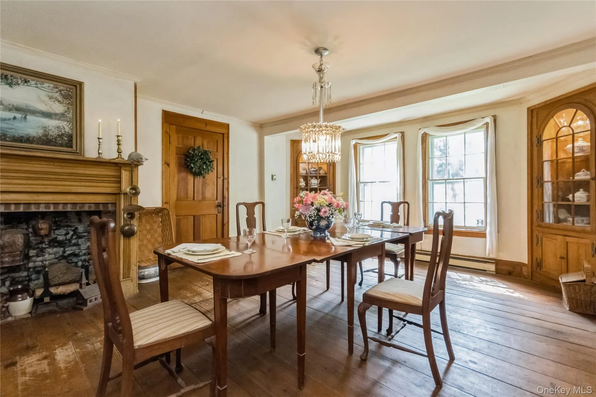 Dining room featuring ornamental molding, a chandelier, wide board flrs, a fireplace Dining room featuring ornamental molding, a chandelier, wide board flrs, a fireplace