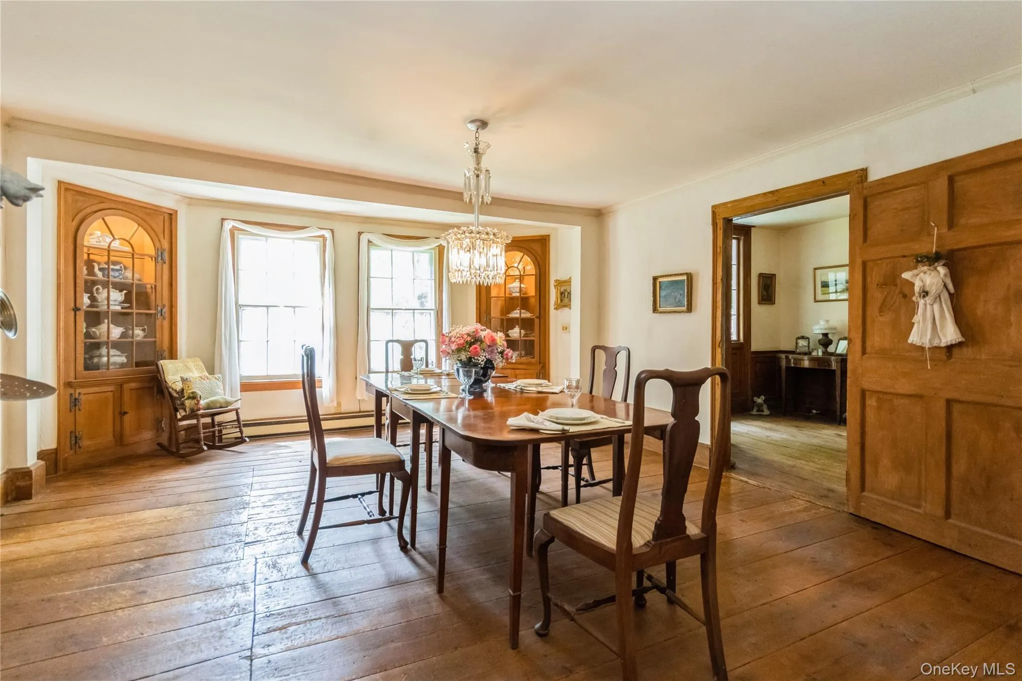 Dining space with wide board flrs, chandelier, crown molding,, built in cabinets Dining space with wide board flrs, chandelier, crown molding,, built in cabinets