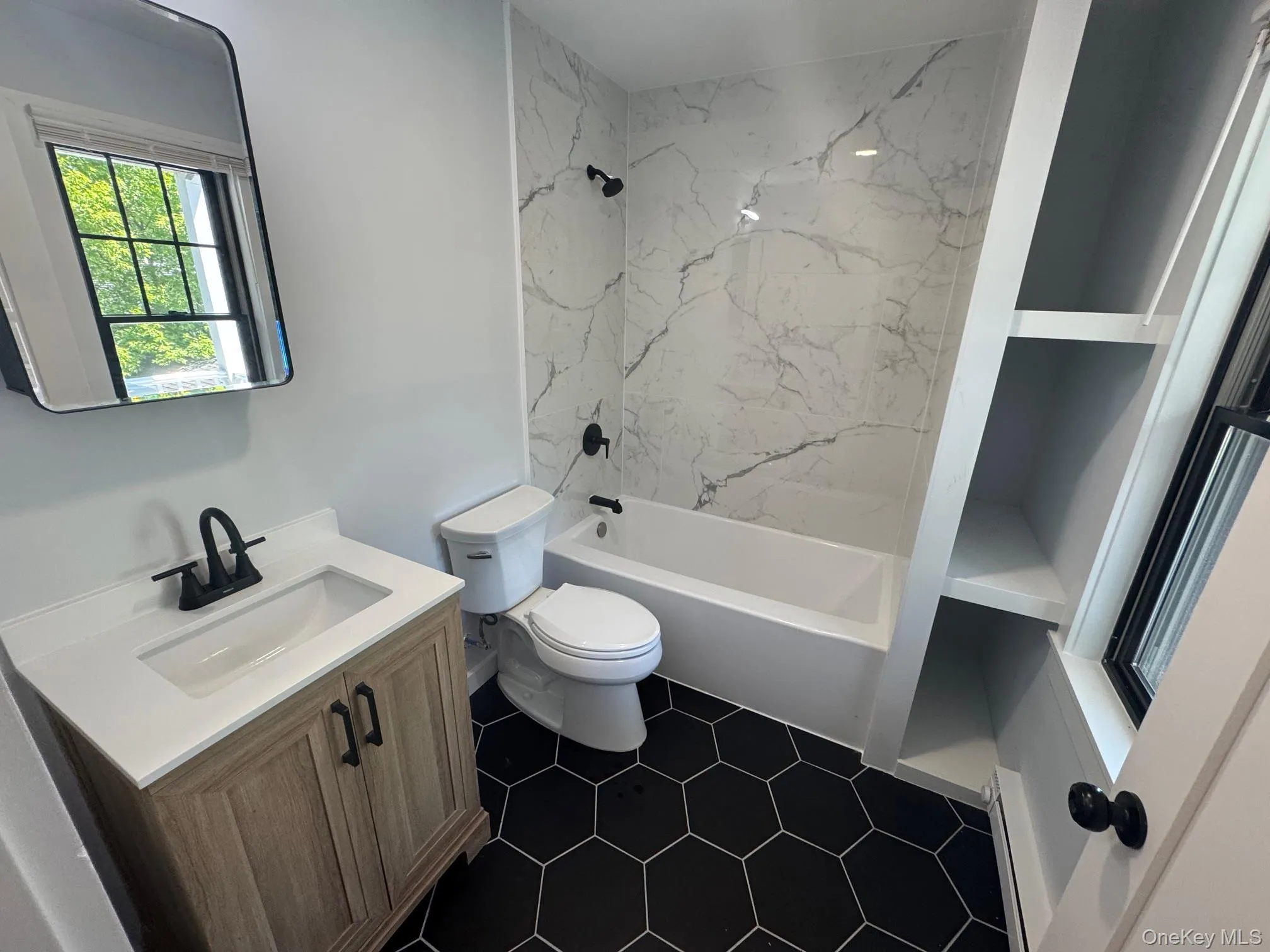 Bathroom featuring vanity, toilet, shower combination, and tile patterned flooring Bathroom featuring vanity, toilet, shower combination, and tile patterned flooring