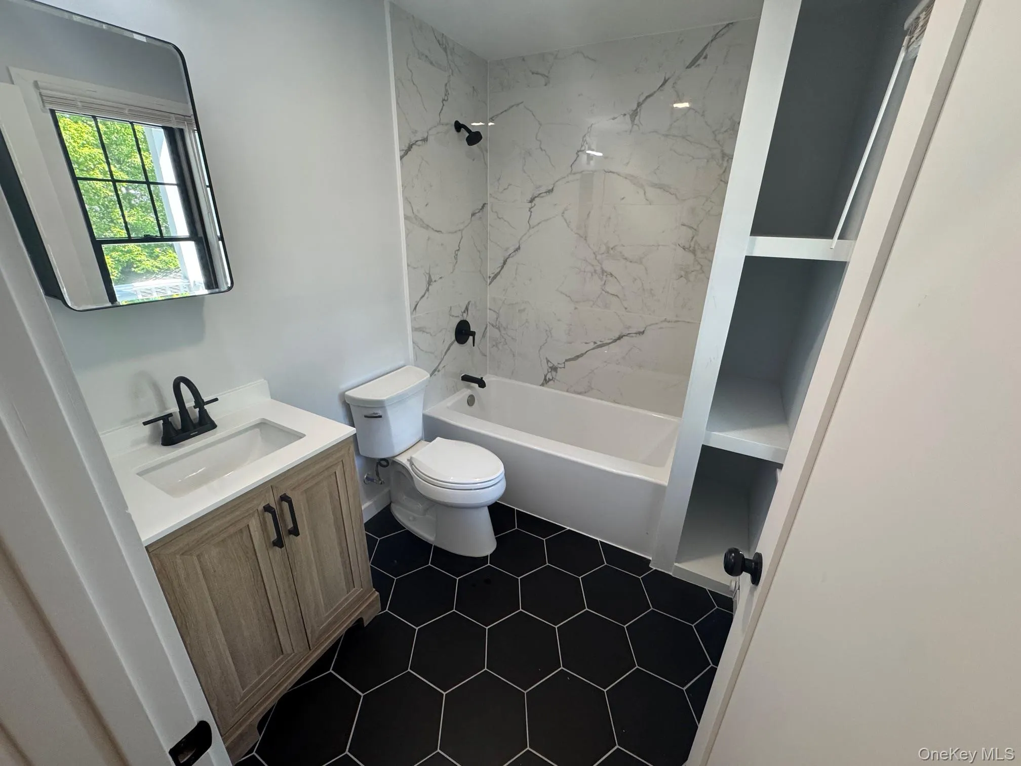 Bathroom with vanity, toilet, bathing tub / shower combination, and tile patterned floors Bathroom with vanity, toilet, bathing tub / shower combination, and tile patterned floors