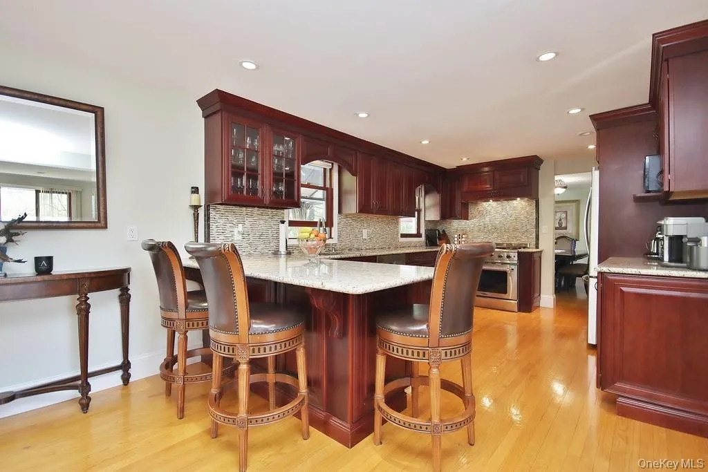 Kitchen has granite counter with seating and glass tile backsplash Kitchen has granite counter with seating and glass tile backsplash