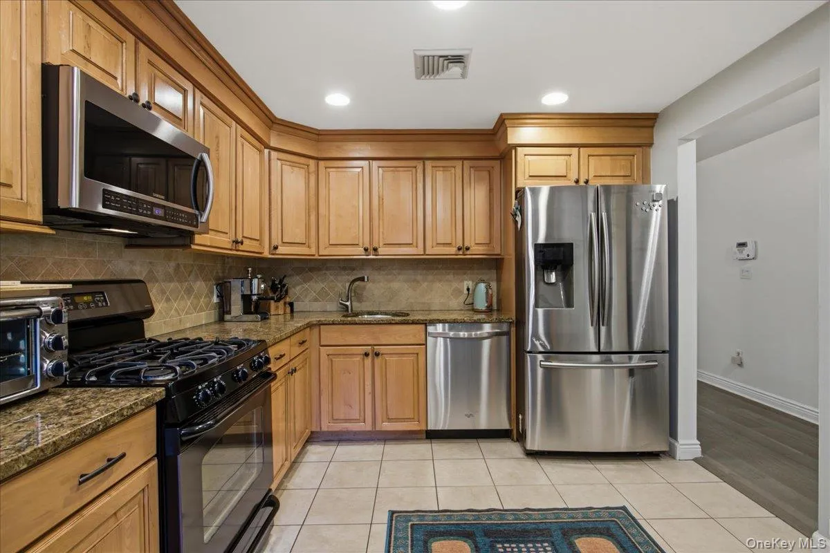Alternate view of the kitchen with granite countertops, stainless steel appliances and ample cabinetry for storage. Alternate view of the kitchen with granite countertops, stainless steel appliances and ample cabinetry for storage.