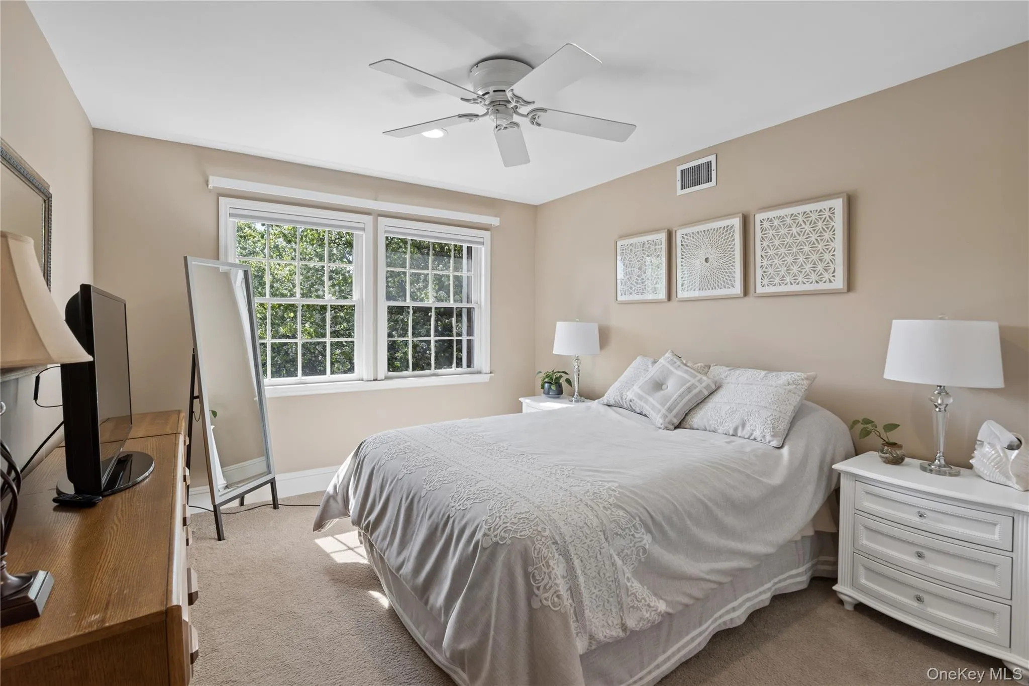 Hardwood flooring, multiple large windows, neutral wall tones, and a ceiling fan Hardwood flooring, multiple large windows, neutral wall tones, and a ceiling fan