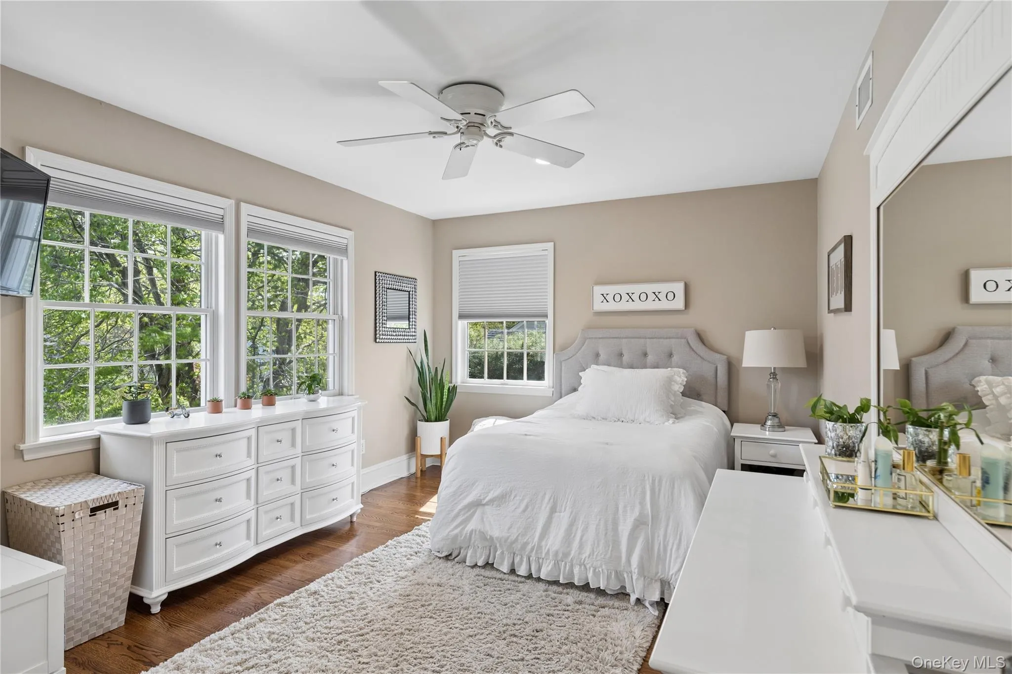 Hardwood flooring, multiple large windows, neutral wall tones, and a ceiling fan Hardwood flooring, multiple large windows, neutral wall tones, and a ceiling fan