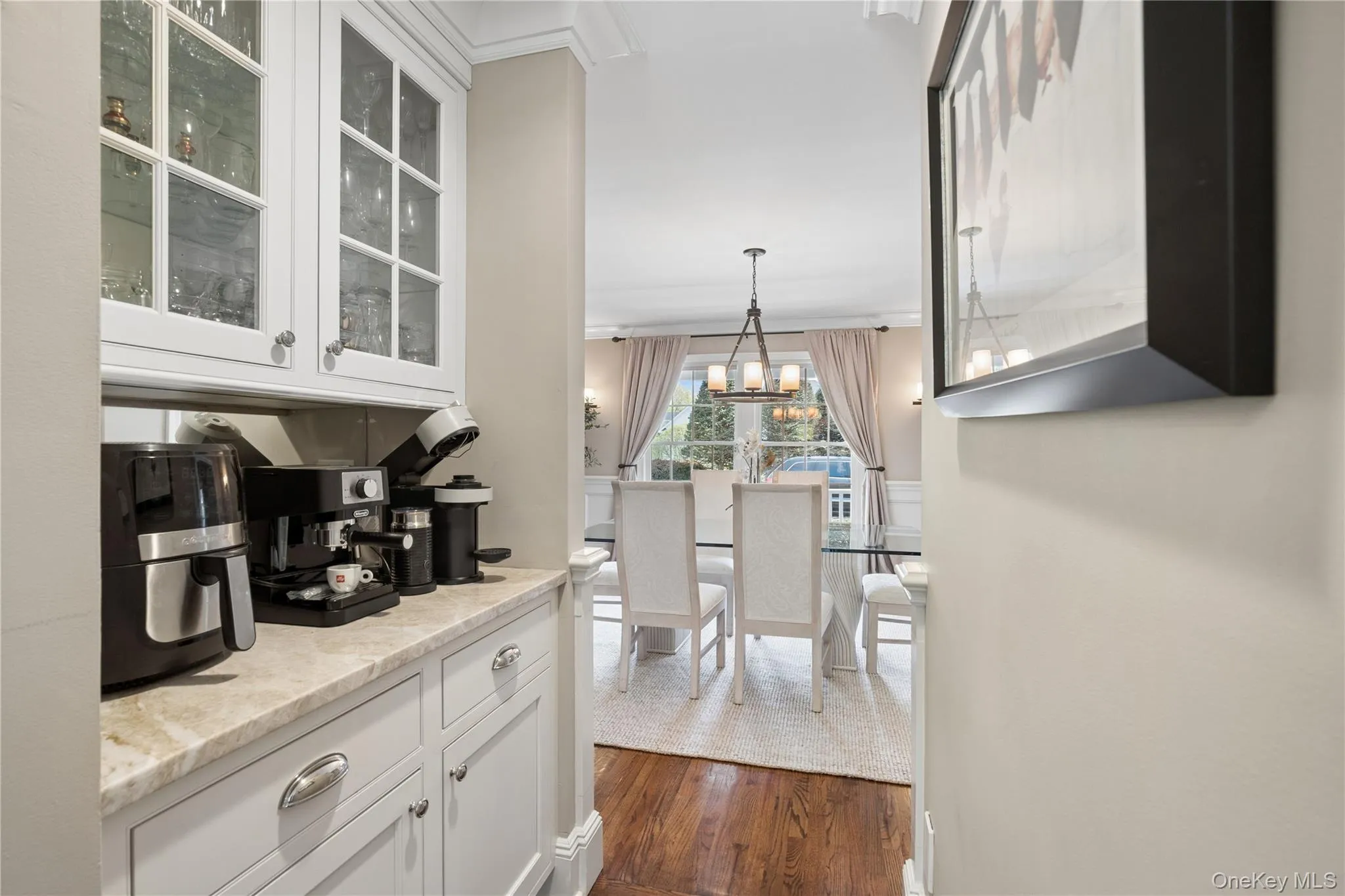Butlers pantry featuring white cabinets, glass doors and quartzite countertops. Butlers pantry featuring white cabinets, glass doors and quartzite countertops.