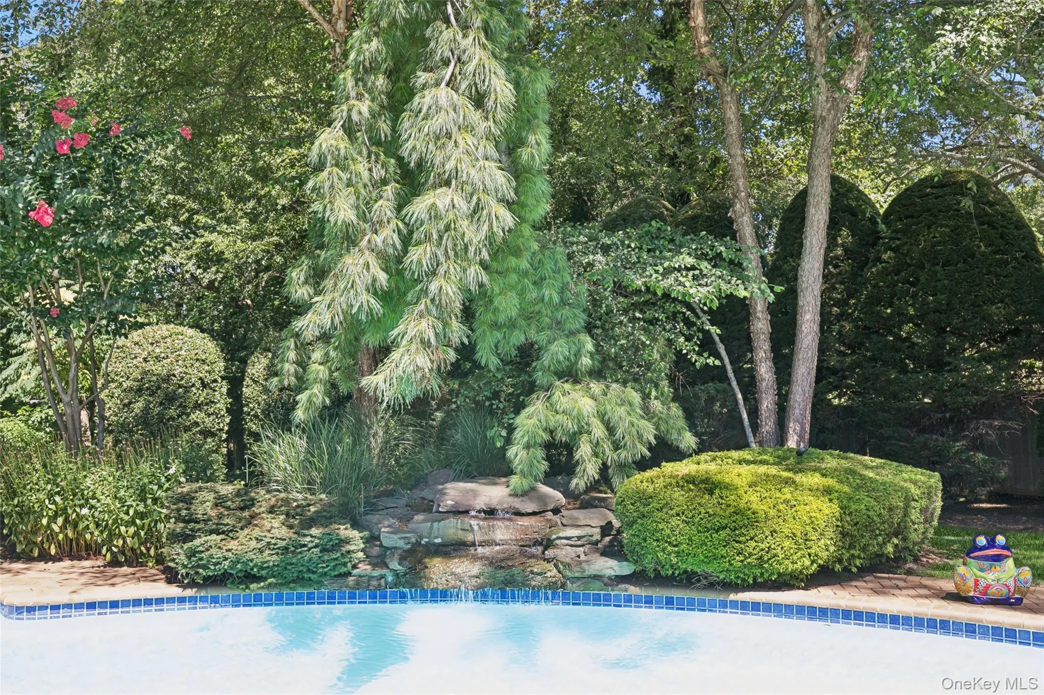 Cascading waterfall accents the gunite kidney shaped pool Cascading waterfall accents the gunite kidney shaped pool