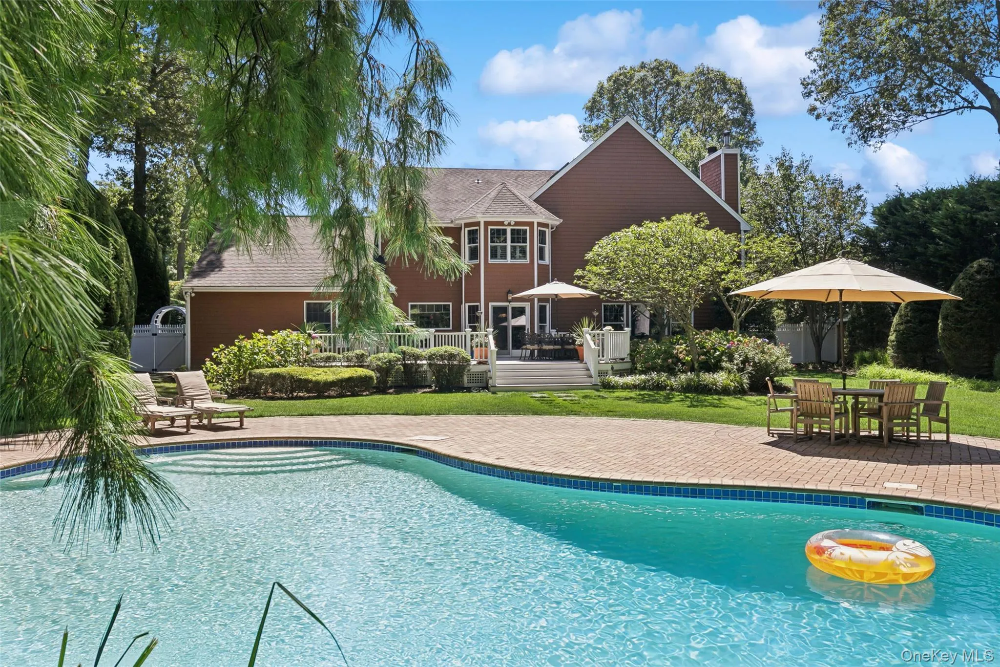 Brick pavers showcase this stunning gunite kidney shaped pool with stone diving rock Brick pavers showcase this stunning gunite kidney shaped pool with stone diving rock