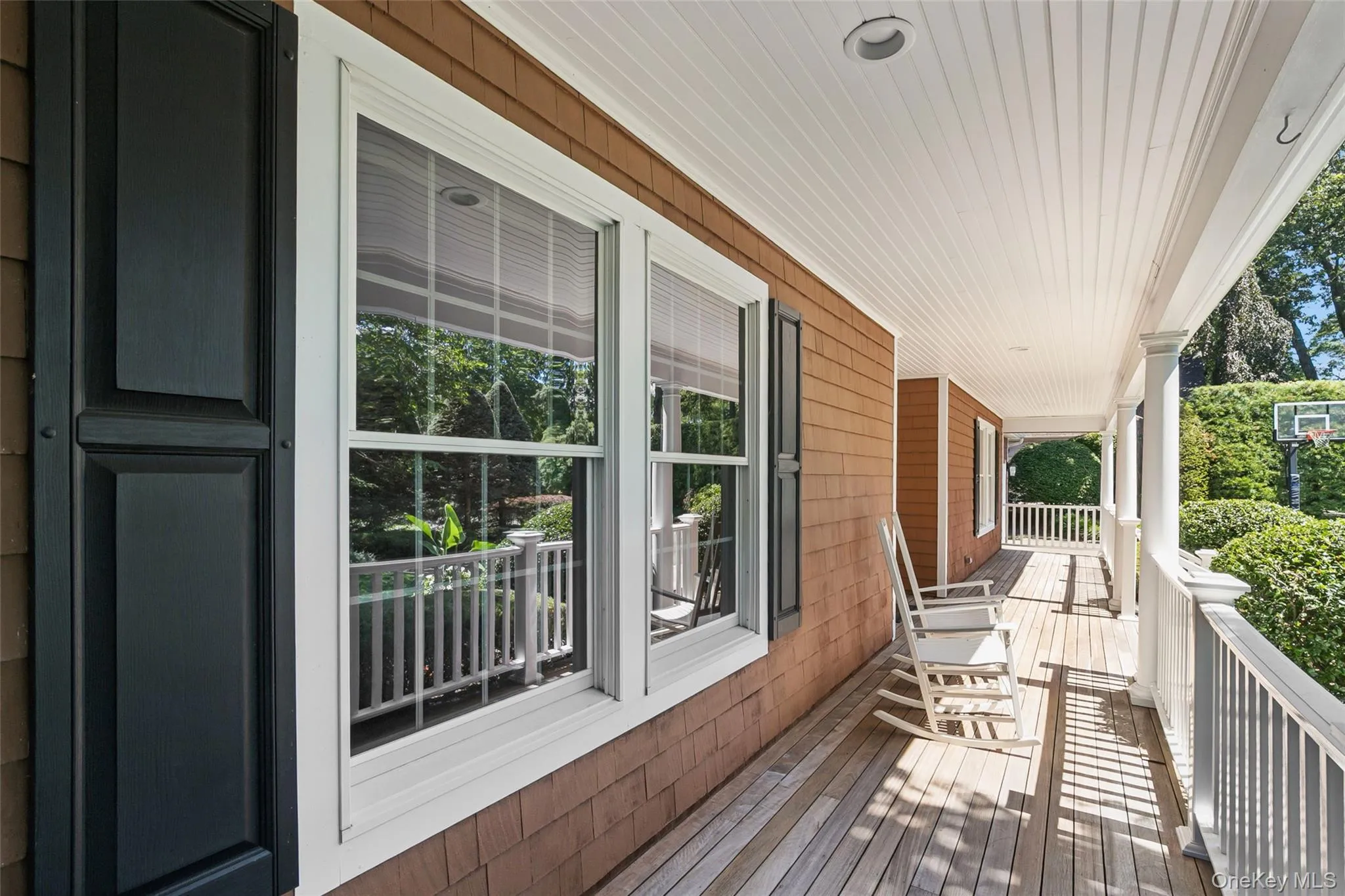 Covered porch featuring wood-finish flooring, white railing, Covered porch featuring wood-finish flooring, white railing,