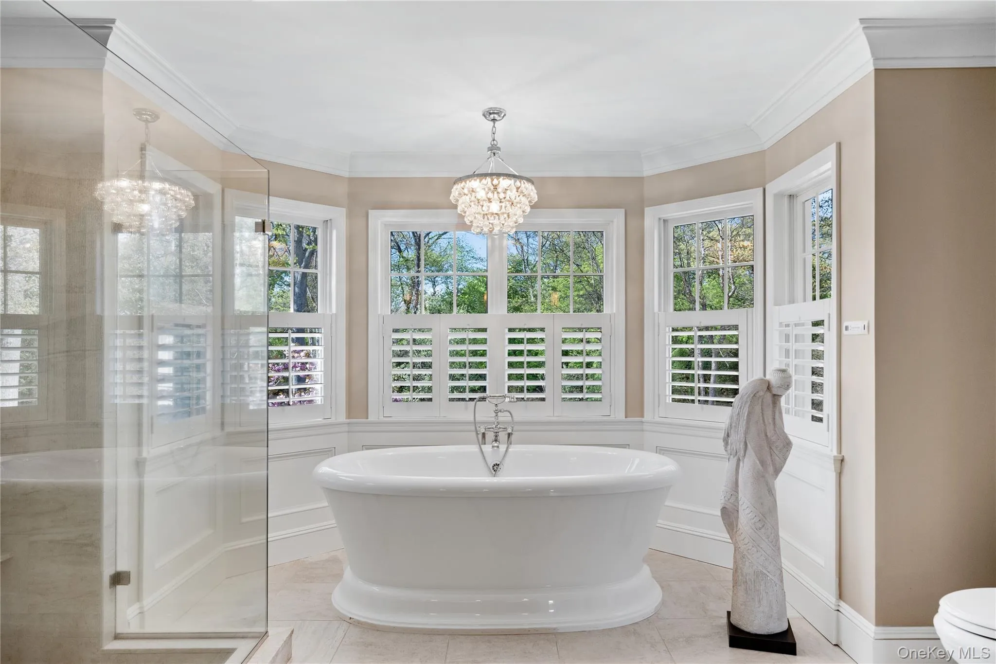 Primary bathroom with walk in tiled shower and freestanding air tub, custom wooden shutters Primary bathroom with walk in tiled shower and freestanding air tub, custom wooden shutters