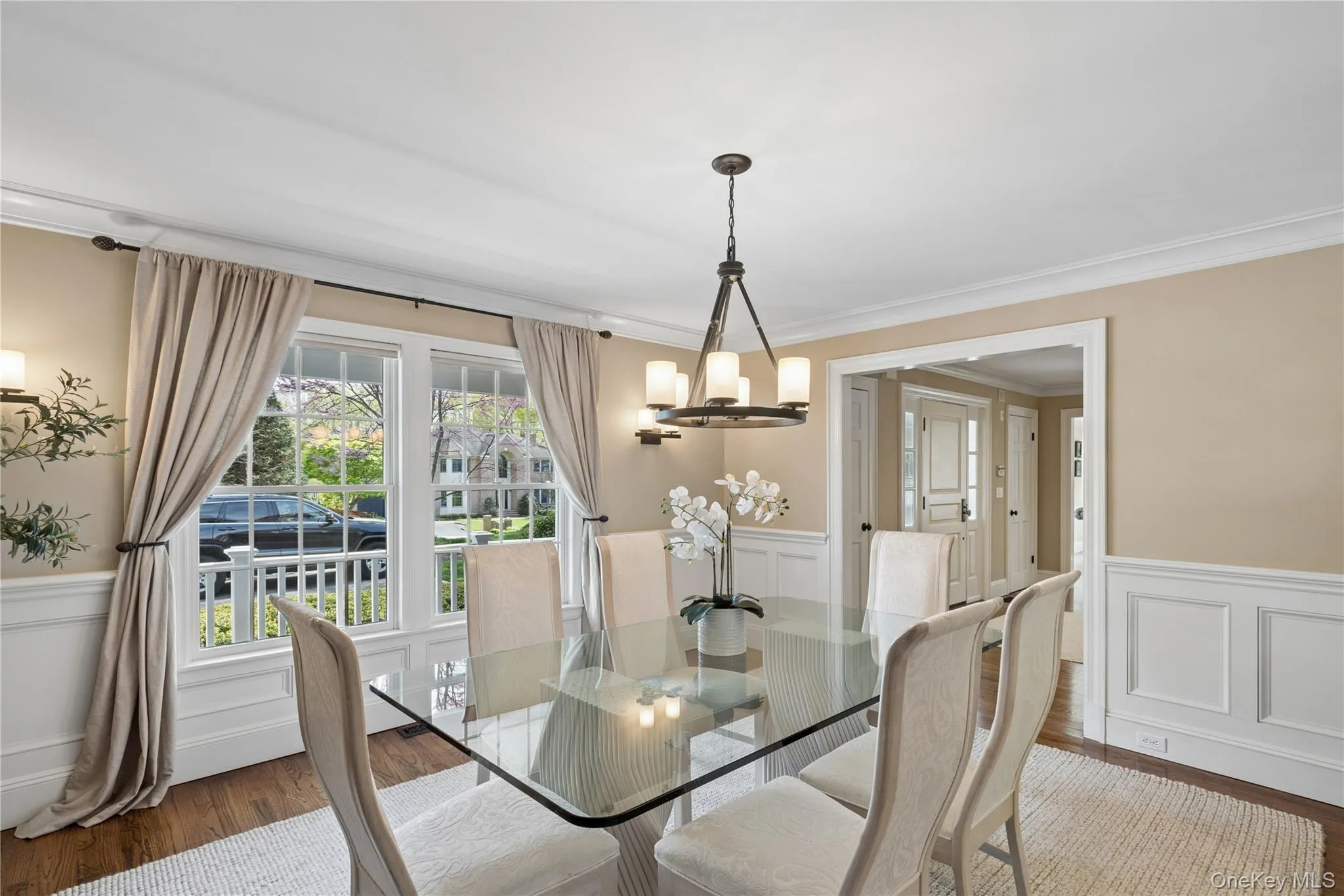 Formal Dining room featuring hardwood flooring, white panel wainscoting, and crown molding Formal Dining room featuring hardwood flooring, white panel wainscoting, and crown molding