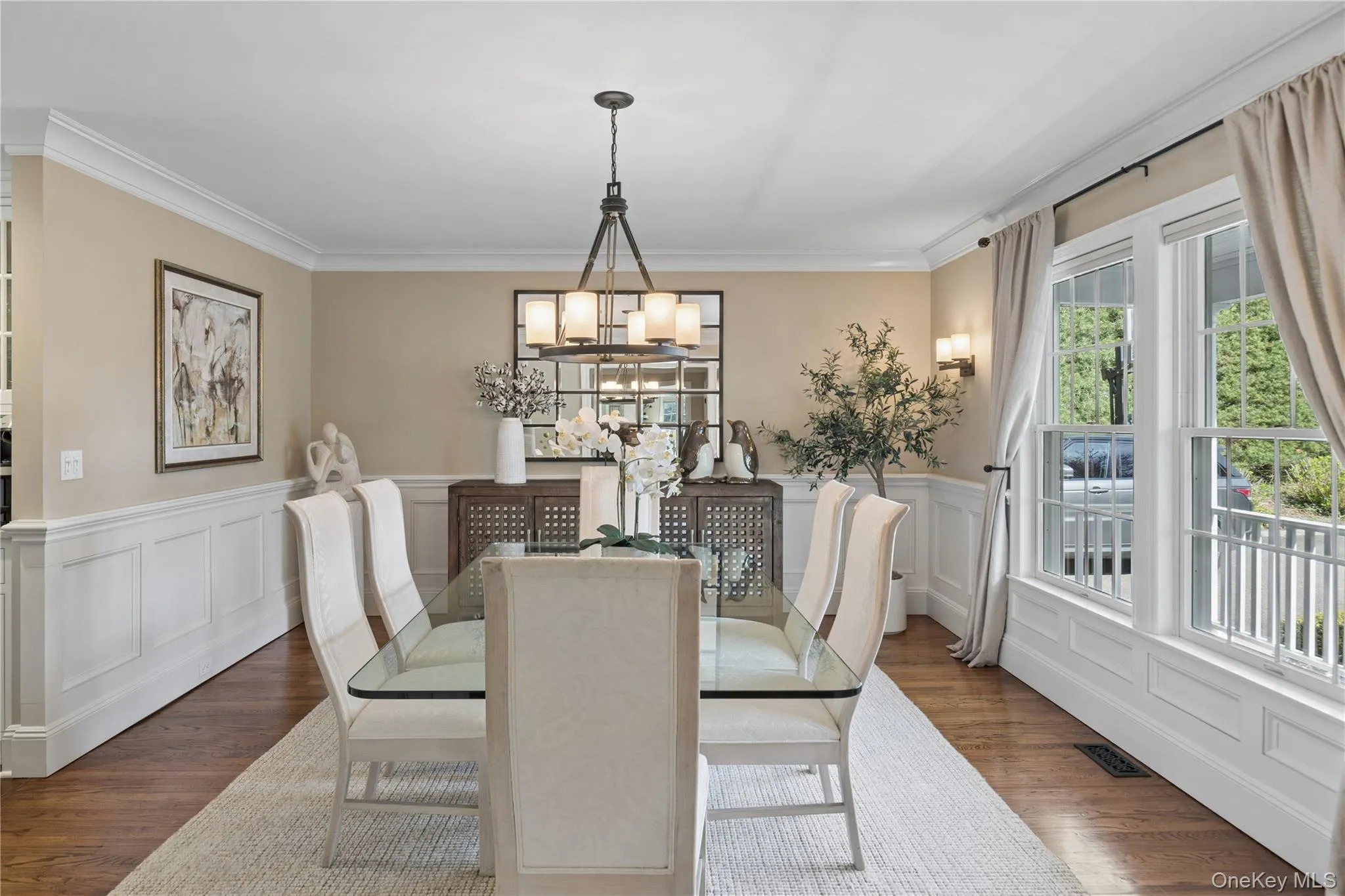 Formal Dining room featuring hardwood flooring, white panel wainscoting, and crown molding Formal Dining room featuring hardwood flooring, white panel wainscoting, and crown molding
