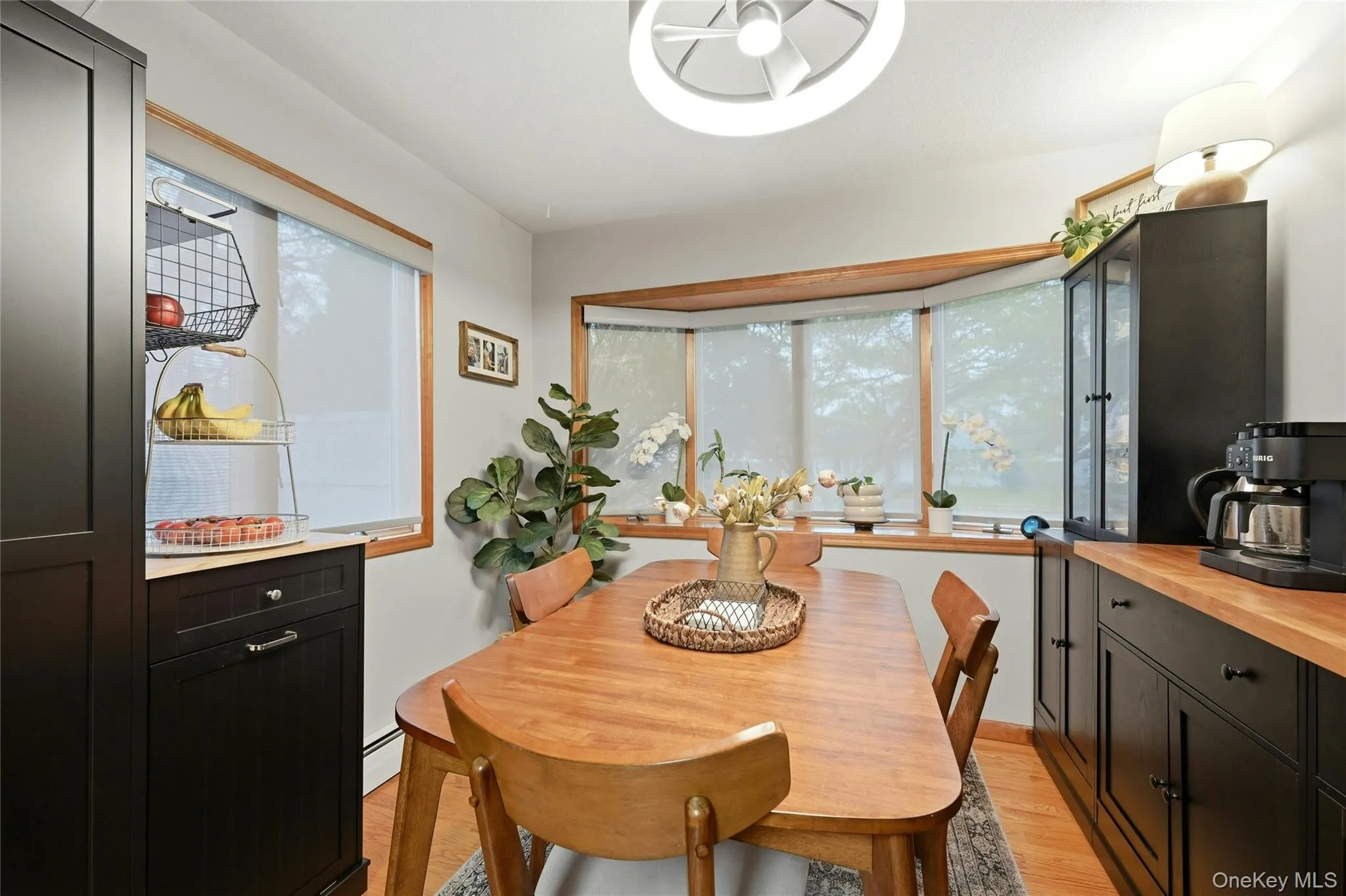 The Sun Filled Dinette Area Offers A Beautiful Bay Window & Separate Double Sized Window For Natural Light, Hardwood Floors, Industrial Style Lighting Fixture/Ceiling Fan & Ample Room For A Large Kitchen Table & Chairs. The Sun Filled Dinette Area Offers A Beautiful Bay Window & Separate Double Sized Window For Natural Light, Hardwood Floors, Industrial Style Lighting Fixture/Ceiling Fan & Ample Room For A Large Kitchen Table & Chairs.