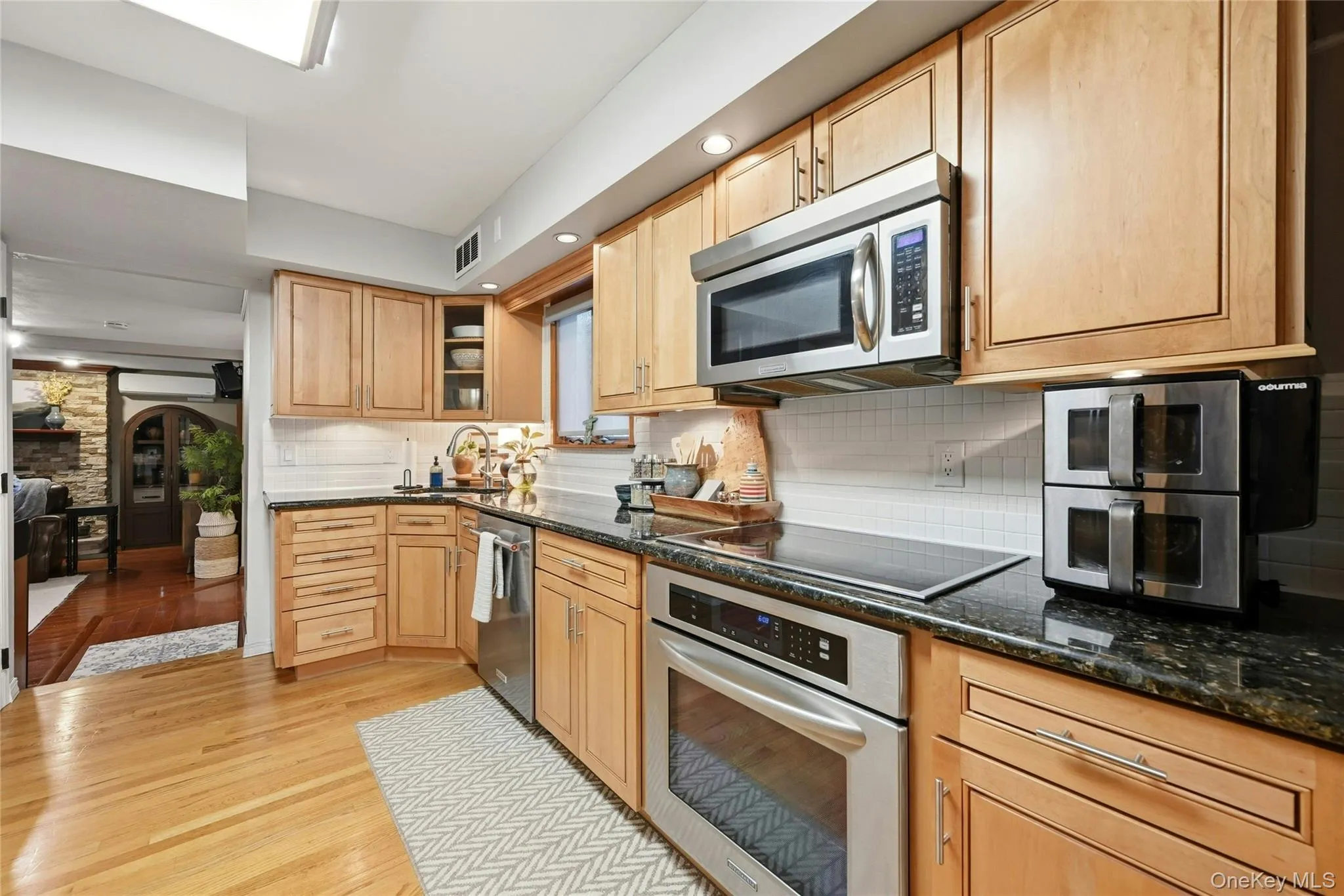 Another View Of The Beautifully Updated & Upgraded Custom Kitchen Offering Walls Of Maple Cabinetry, Granite Countertops With An Undermount Sink & Ample Counter/Serving Spaces, Tiled Backsplash, Stainless Steel Appliances, Hardwood Floors & A Separate Sun Filled Dinette Area. Another View Of The Beautifully Updated & Upgraded Custom Kitchen Offering Walls Of Maple Cabinetry, Granite Countertops With An Undermount Sink & Ample Counter/Serving Spaces, Tiled Backsplash, Stainless Steel Appliances, Hardwood Floors & A Separate Sun Filled Dinette Area.