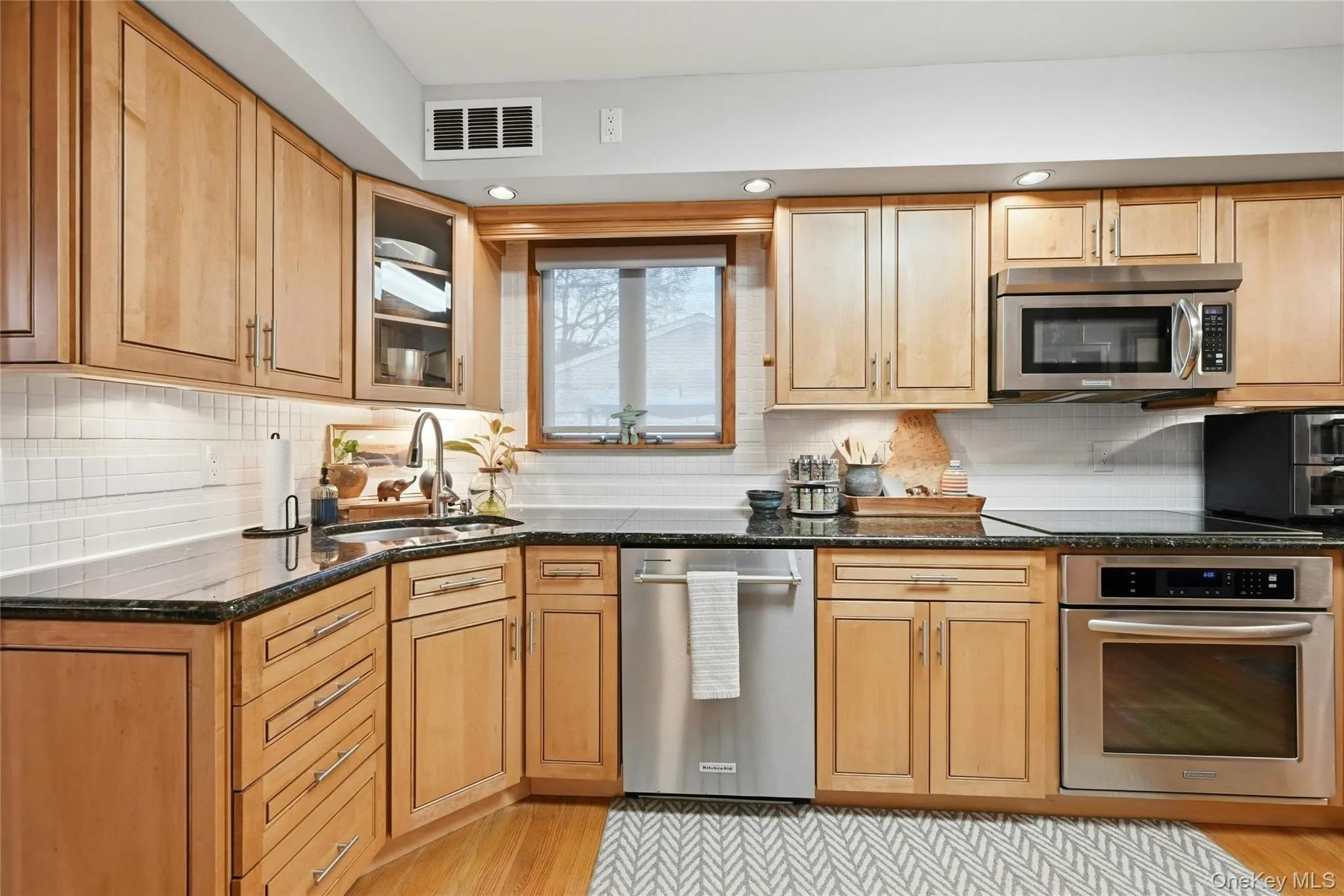 The Beautifully Updated & Upgraded Custom Kitchen Offers Walls Of Maple Cabinetry, Granite Countertops With Undermount Sink & Ample Counter/Serving Spaces, Tiled Backsplash, Stainless Steel Appliances, Hardwood Floors & A Separate Sun Filled Dinette Area. The Beautifully Updated & Upgraded Custom Kitchen Offers Walls Of Maple Cabinetry, Granite Countertops With Undermount Sink & Ample Counter/Serving Spaces, Tiled Backsplash, Stainless Steel Appliances, Hardwood Floors & A Separate Sun Filled Dinette Area.