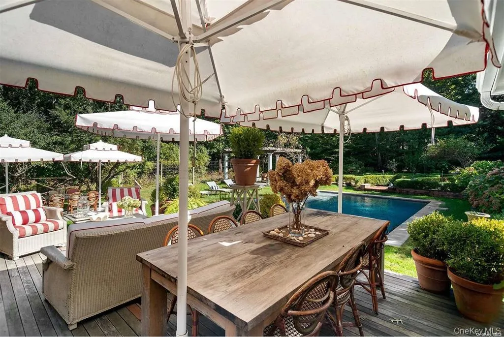Outdoor dining and seating area overlooking the pool and landscaped grounds. Outdoor dining and seating area overlooking the pool and landscaped grounds.